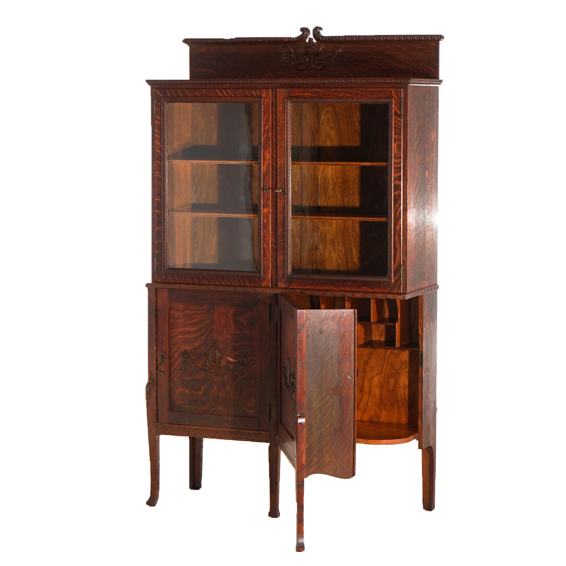 ***Ask About Reduced In-House Shipping Rates - Reliable Service & Fully Insured***

An antique secretary in the manner of Horner offers quarter sawn oak construction with double door bookcase having crest with carved scroll elements over lower case