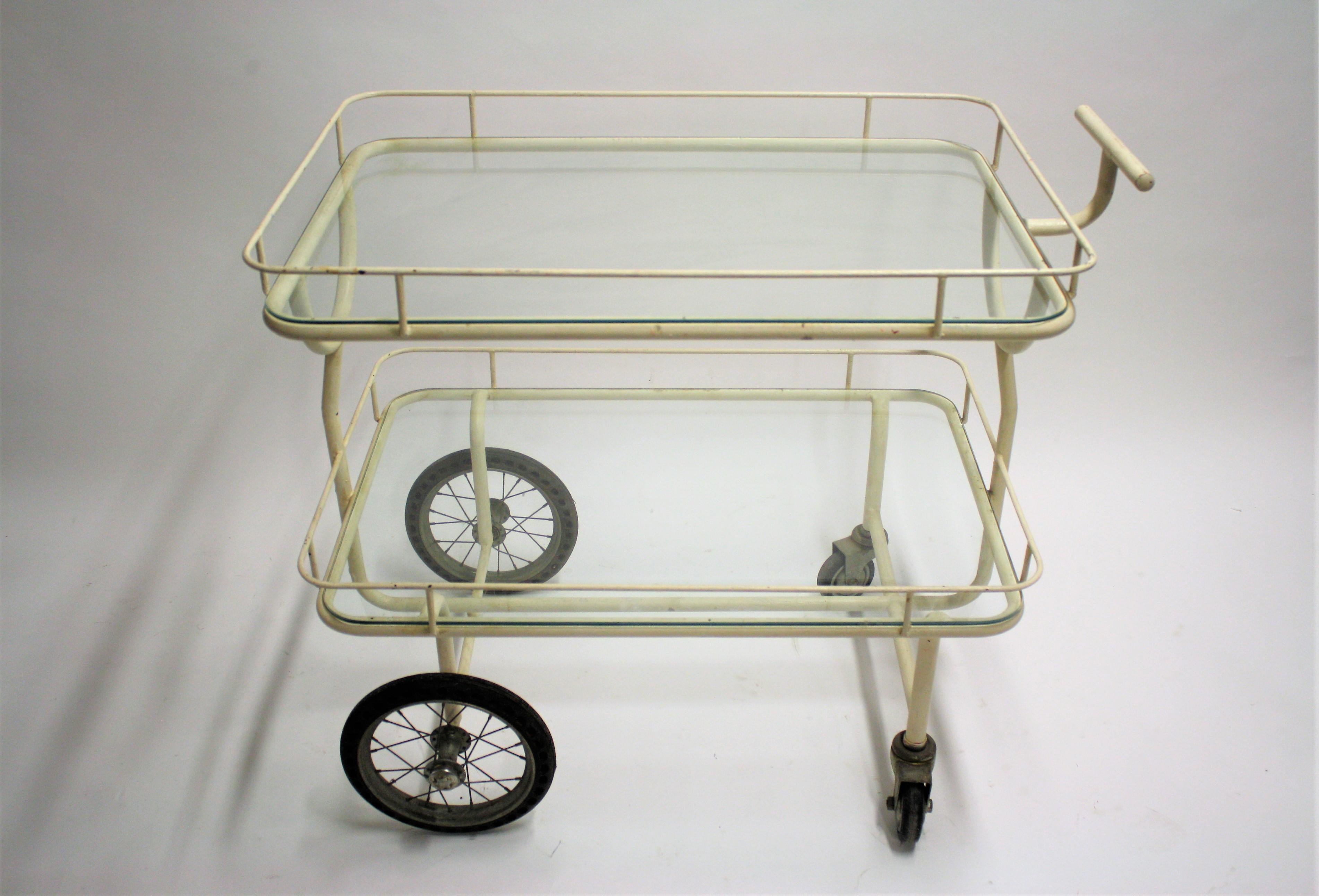 A beautiful all original French 1930s-1940s two-tier hospital trolley made from steel and glass.

It still has the original spoked wheels with tires and casters.

Wonderful patina.

The large size makes it ideal as a serving trolley but it