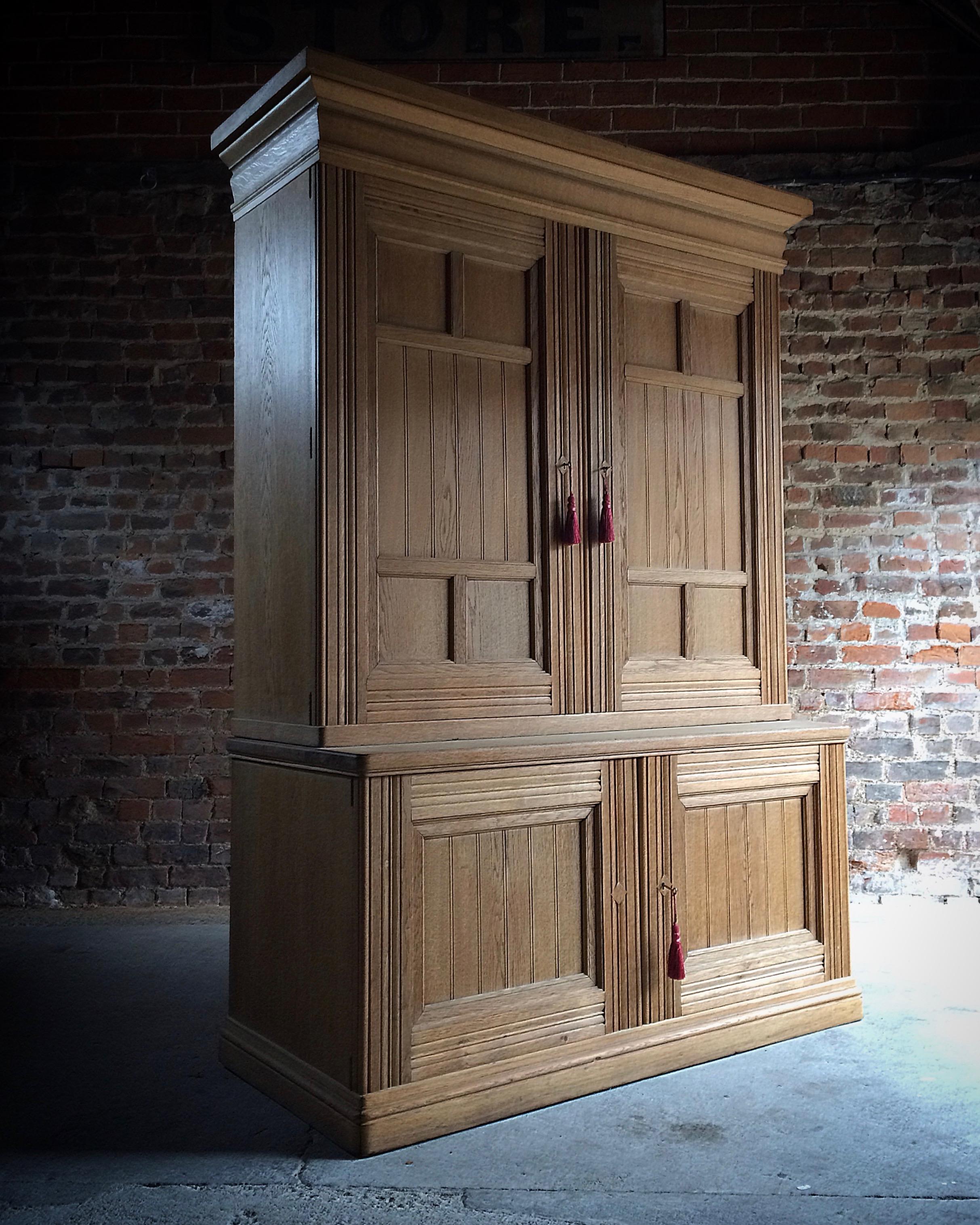 A large late 19th century ash Housekeepers cupboard circa 1890 the large overhanging cornice over a large pair of panelled doors, opening to reveal fitted interior with numerous shelves and four drawers, maker's mark and monogram to one door, over