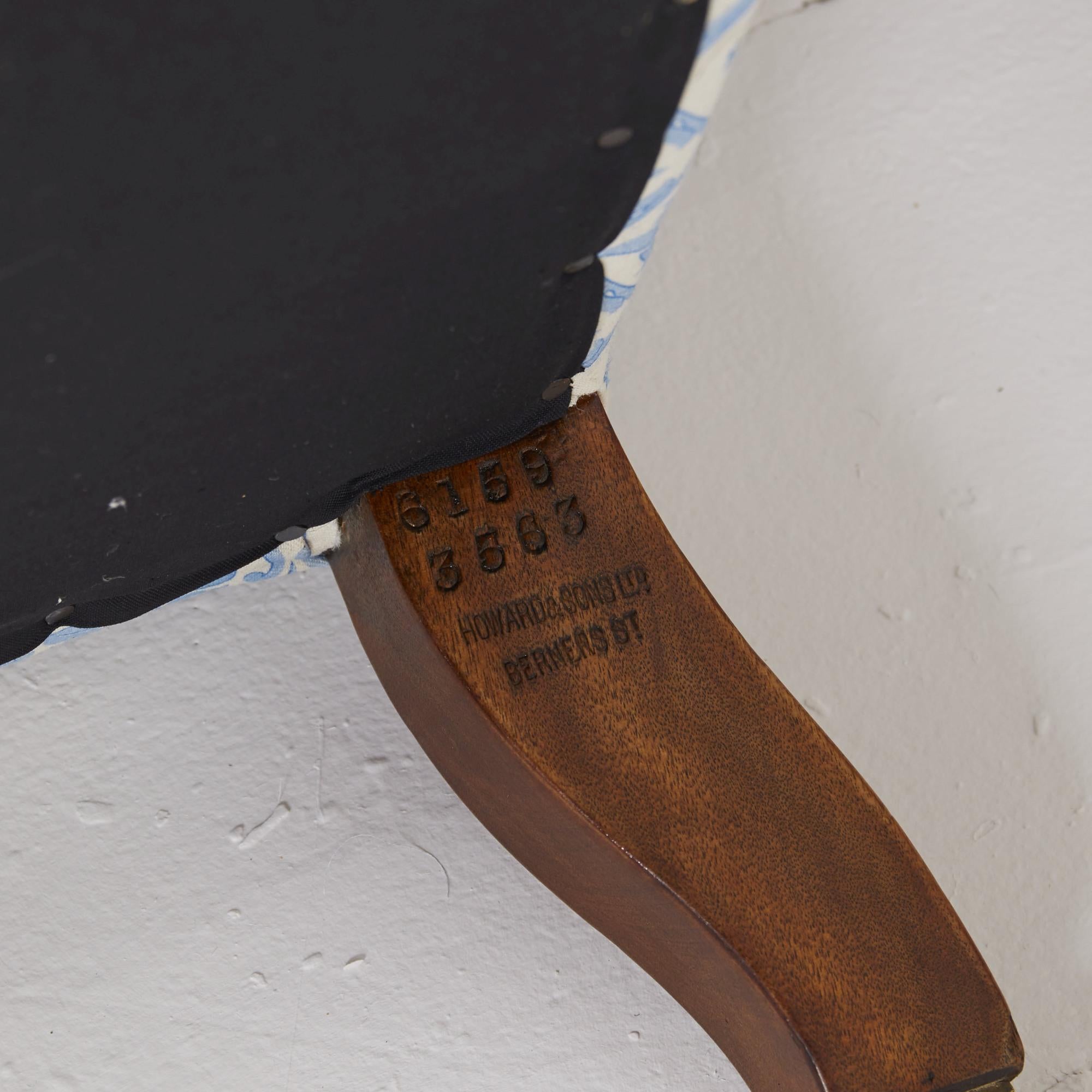 Fauteuil modèle Willoughby de Howard and sons recouvert de coutil bleu H&S

reposant sur des pieds tournés en noyer anglais et des roulettes d'origine, ainsi que sur un pied arrière évasé estampillé.

Dossier et coussin d'assise en plumes de canard