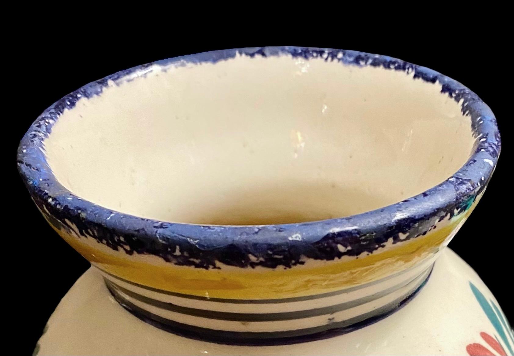 Atractivo jarrón de loza francesa Antique HR Quimper de la década de 1960, bien esmaltado y pintado suavemente en una paleta tradicional, con la figura de un Petit Breton, de pie, mirando hacia la derecha, con la fusta en la mano, entre frondas de