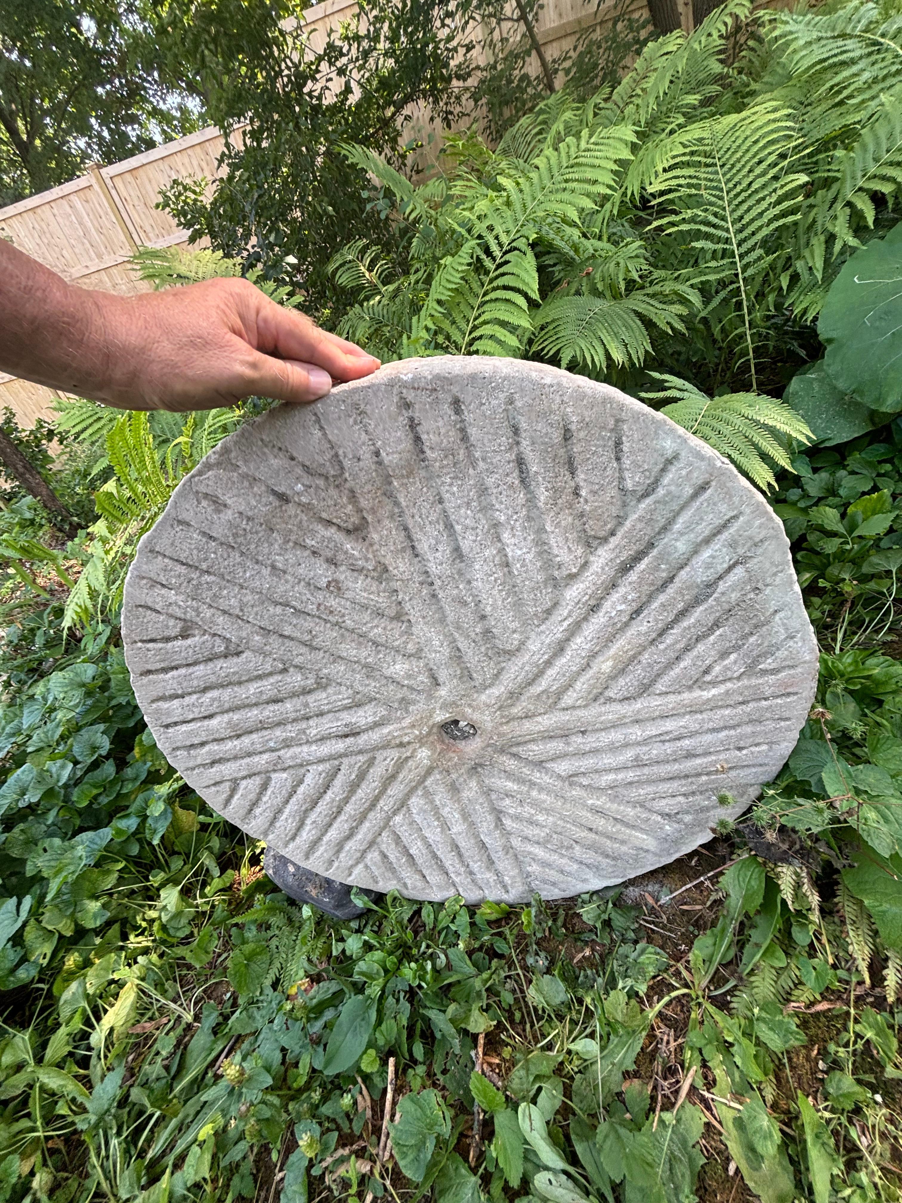 Cette grande pierre de moulin ronde de 26 pouces de diamètre et de 5 pouces d'épaisseur, sculptée à la main et datant du 19e siècle ou d'une période antérieure, nous vient de Chine. Il s'agit probablement d'une pierre de base pour le broyage d'un