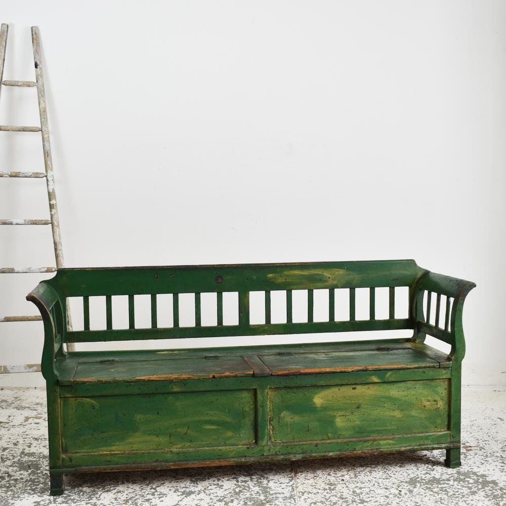 Dark green antique Hungarian settle bench.

An original settle bench salvaged from an Hungarian farmhouse. The bench has been left in its original condition, made from pine and painted in a dark green colour. The bench has some lovely original