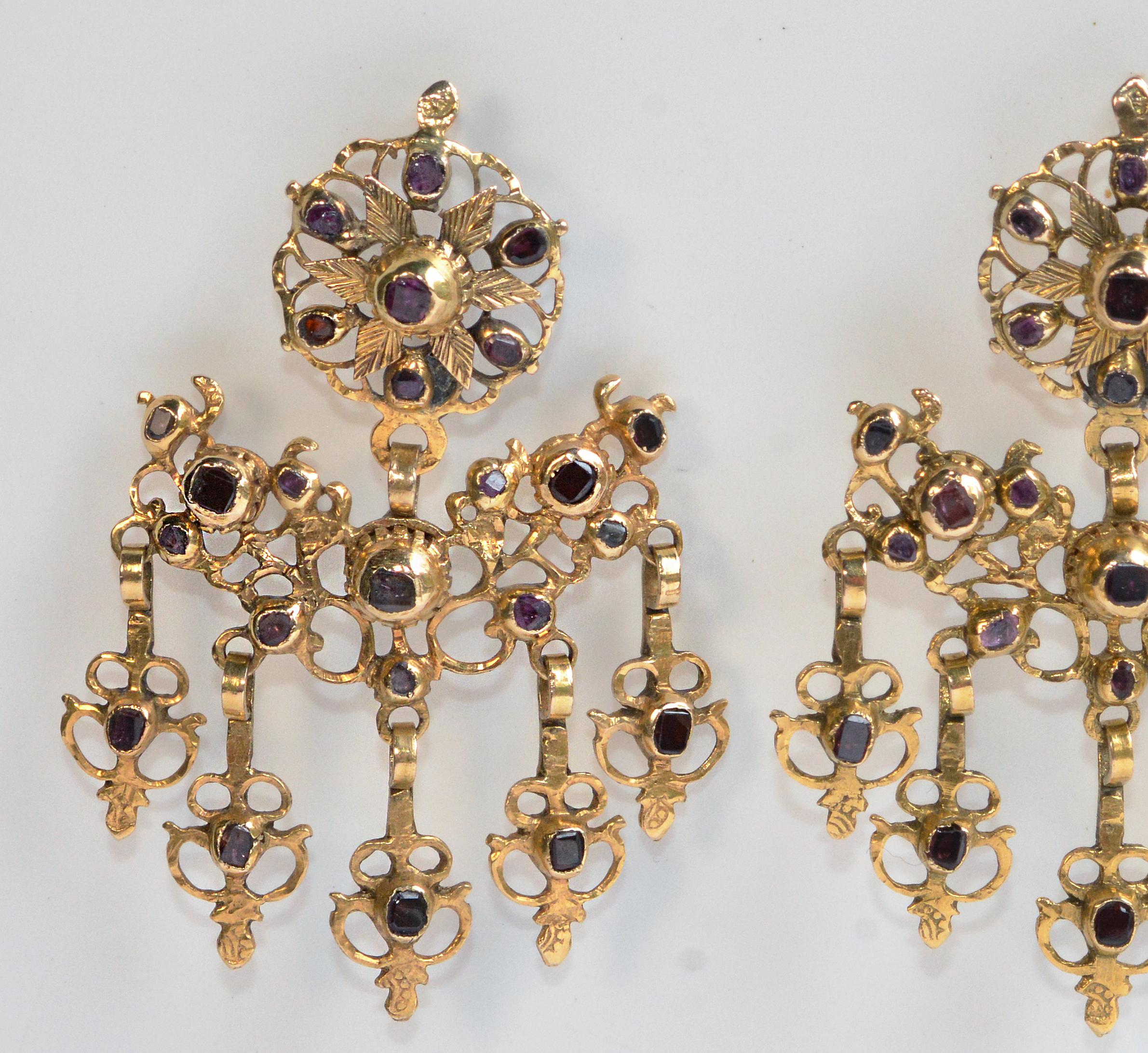 An amazing and rare pair of original gold and garnet Iberian earrings, circa 1770. These beautiful pieces of history are striking and regal. They feature a mix of foil backed red and pink, flat and table cut garnets in closed back settings. The