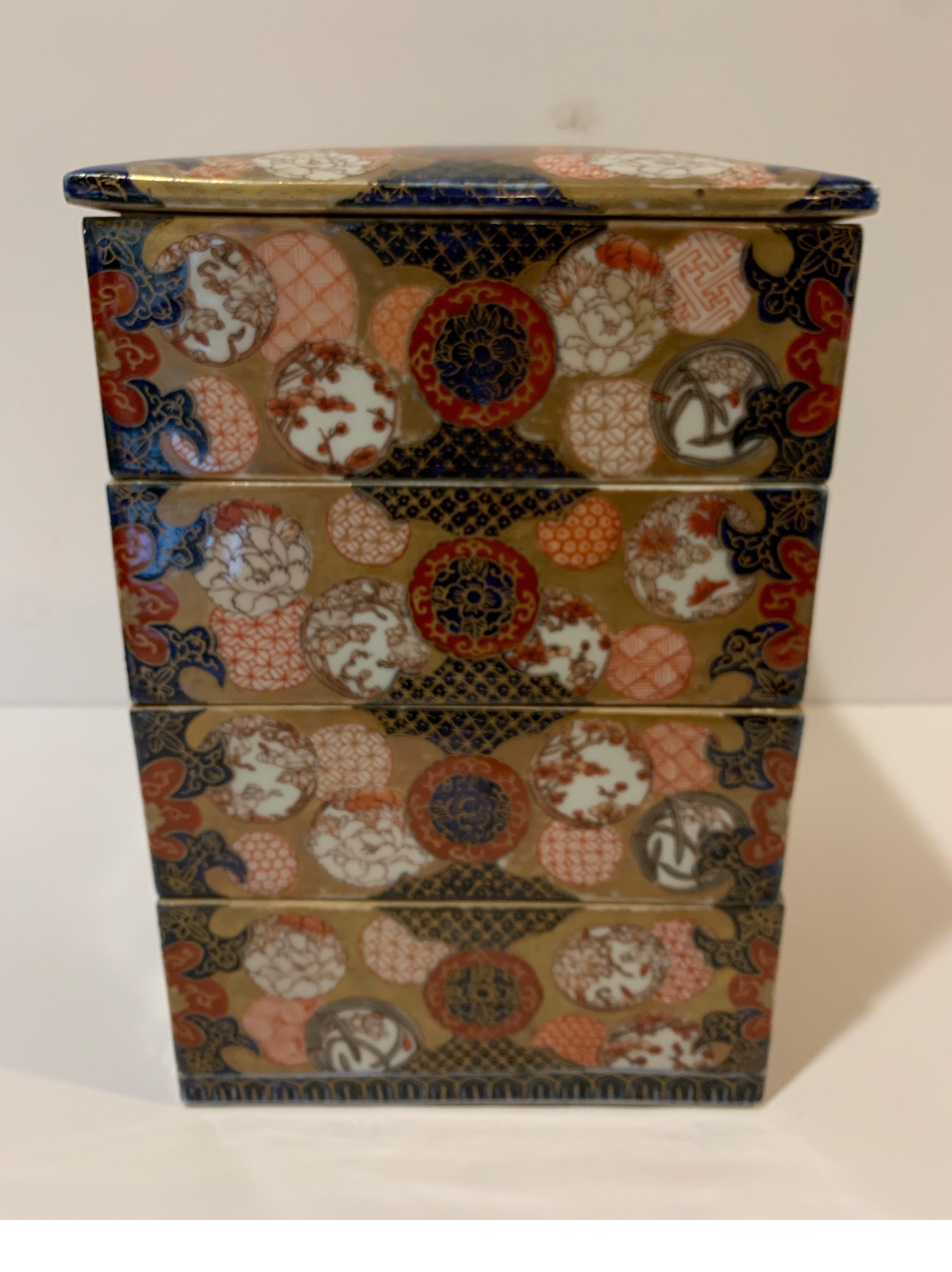 Unusual Japanese porcelain stack box vessel. The set of four boxes with top lid exquisitely painted in the Classic Imari iron red and cobalt blue with all-over gilt decoration. Finest imperial quality.