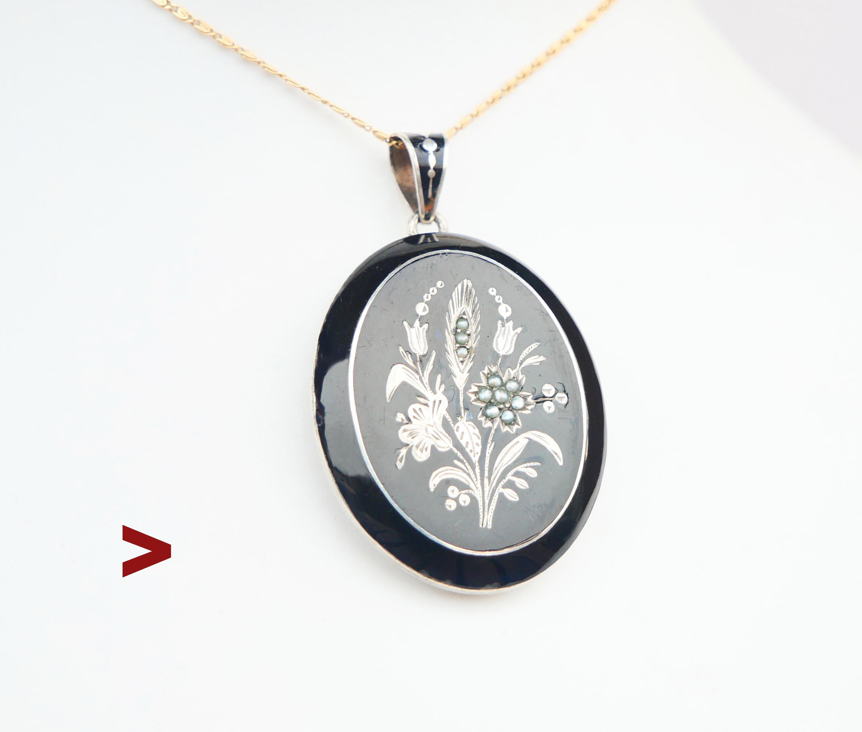 Antico ciondolo austriaco-ungherese o boemo con medaglione, decorato con raffinate incisioni floreali, smalto nero e perle a seme. Tutte le parti metalliche sono in argento 830 massiccio. Scomparti interni dorati per le fotografie, con lunette