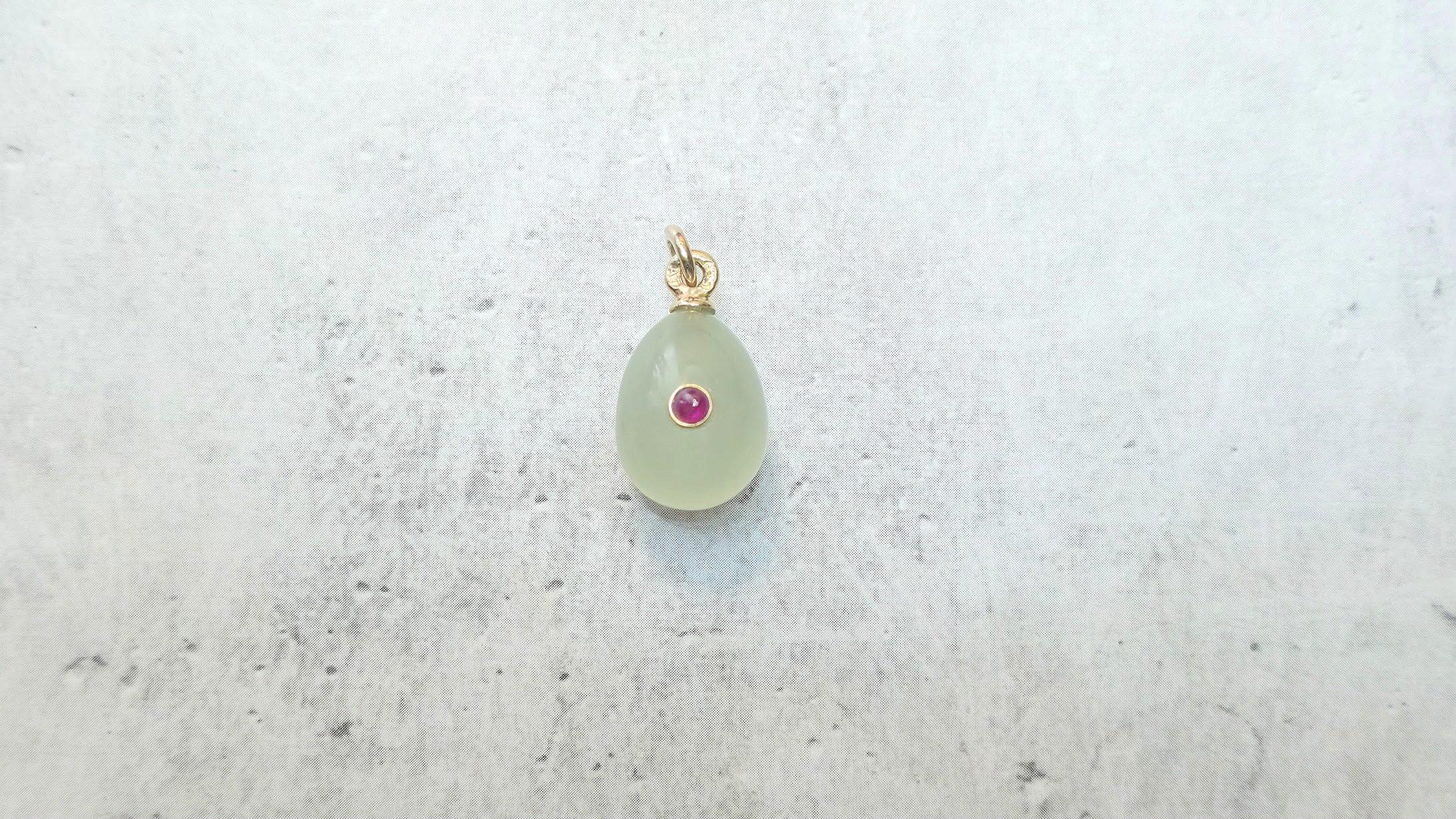 Wir freuen uns, Ihnen ein weiteres außergewöhnliches Stück aus unserer Kollektion präsentieren zu können - einen charmanten Miniatur-Ei-Anhänger aus massivem Gold, der aus Bowenit gefertigt und mit einem natürlichen Rubin verziert ist. Das goldene