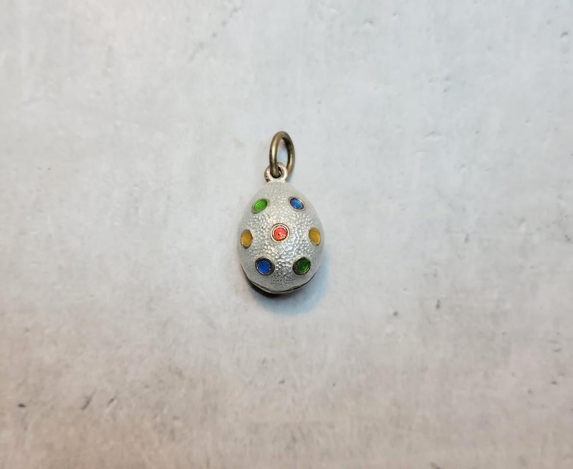 A Fabergé workmaster, Anders Johan Nevalainen, crafted a silver egg pendant adorned with guilloché white enamel and featuring a relief design of multi-colored polka dots. It was made in St. Petersburg, Russian Empire, in the early 20th