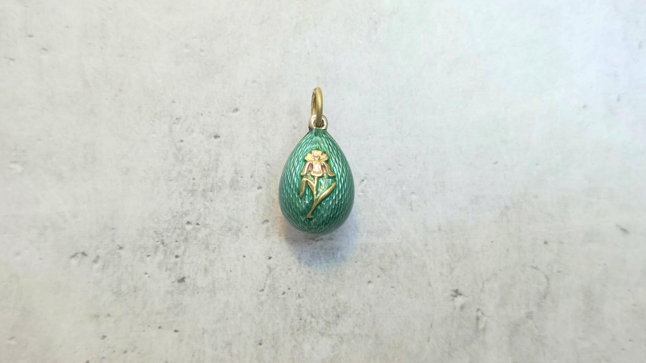 Siamo lieti di presentare un altro articolo unico della nostra collezione: un elegante ciondolo a forma di uovo in miniatura ornato di smalto guilloché risalente all'epoca dell'Impero Russo. Questo squisito pezzo è stato realizzato a San Pietroburgo