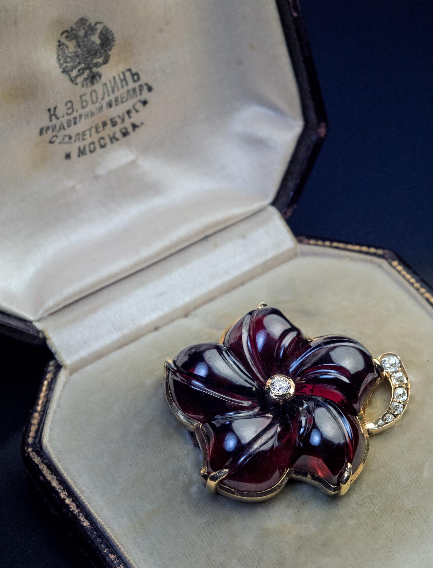 This rare antique brooch by BOLIN, a jeweler of the Russian Imperial court, was made in St. Petersburg in the 1890s.

The brooch is designed as a finely carved almandine garnet flower set is 14K gold and accented with old mine cut diamonds.

Marked