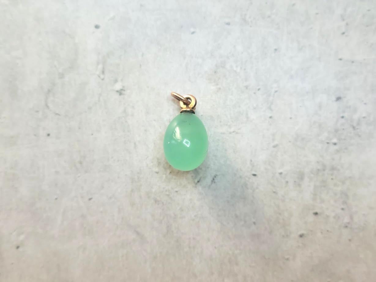 We present to you an exquisite miniature egg-shaped pendant crafted from green chrysoprase and gold. This unique piece was created by Livonian jeweler Phillip Theodor Ringe, who worked in the workshops of the House of Fabergé, which was made in St.