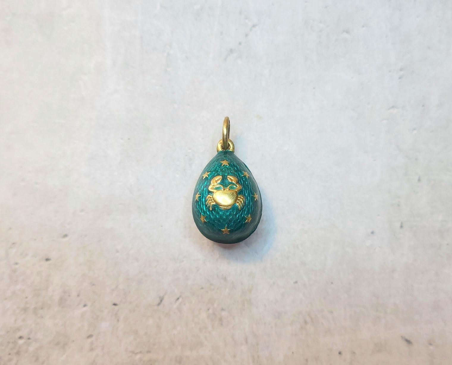 We present to you an exquisite silver-gilded egg pendant. Its body is adorned with vibrant emerald guilloché enamel, creating a silky texture, while gilded accents add a refined matte finish, enhancing its timeless charm. The intricate decoration,