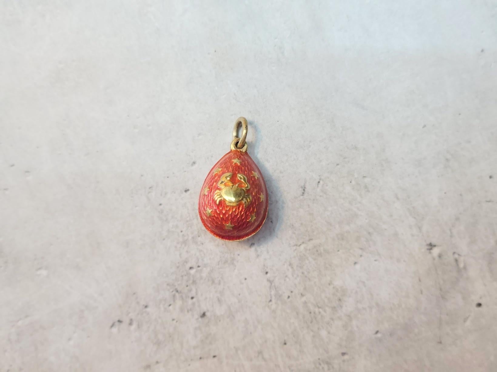 We present to you an exquisite silver-gilded egg pendant. Its body is adorned with vibrant orange guilloché enamel, creating a silky texture, while gilded accents add a refined matte finish, enhancing its timeless charm. The intricate decoration,