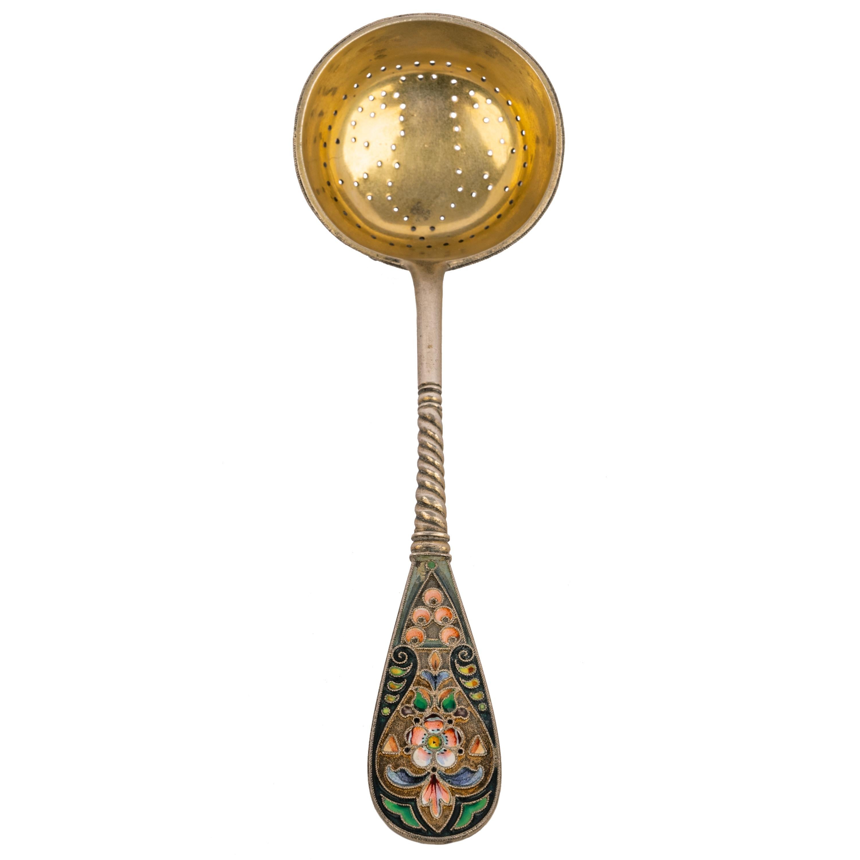A good antique Russian Imperial silver-gilt cloisonné enamel tea strainer, Moscow, circa 1908.
The handle having floral enamel decoration to the front & rear and a spiral stem, the exterior of the bowl having corresponding cloisonné decoration and