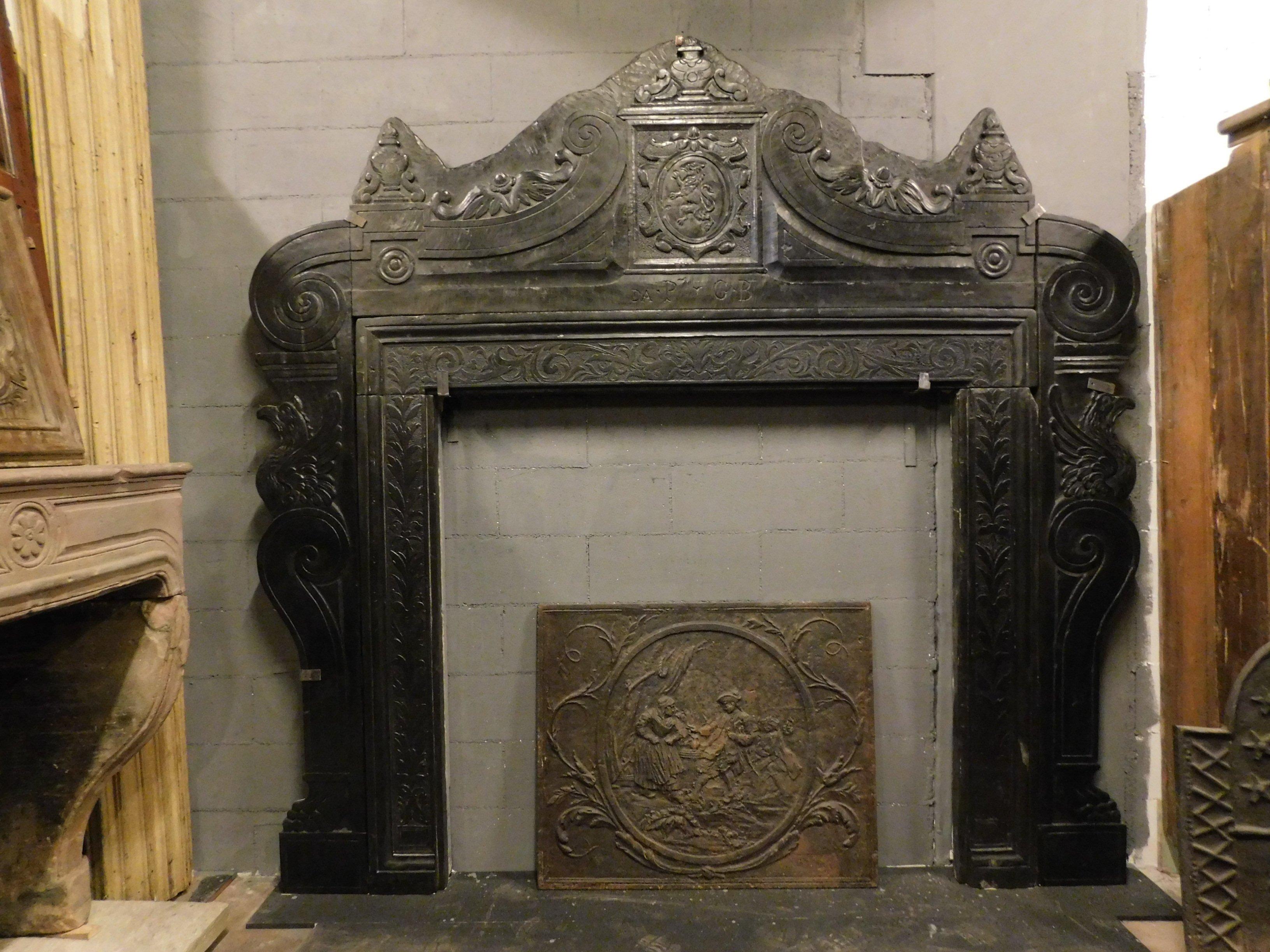 Ancient and imposing fireplace mantle in precious black slate stone, richly hand carved with noble family coat of arms, central coat of arms, cups and eagles on the uprights, parts already restored but of great beauty, entirely produced in the 16th