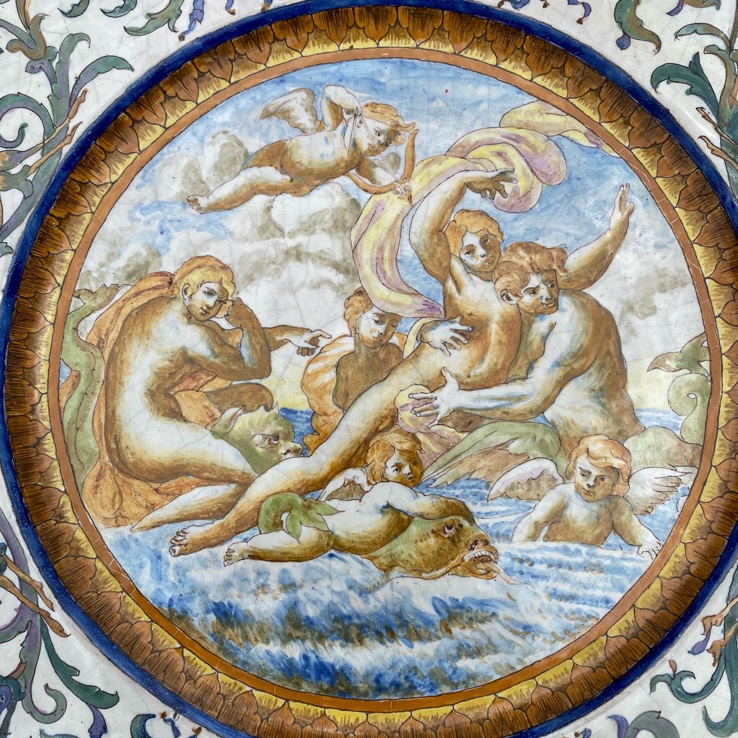 This beautifully hand painted Italian Majolica plate is made of tin glazed earthenware from the early 1800s. The mythological scene shows angels and cherubs in the sea with enchanting sea creatures. The border of the plate depicts a motif of