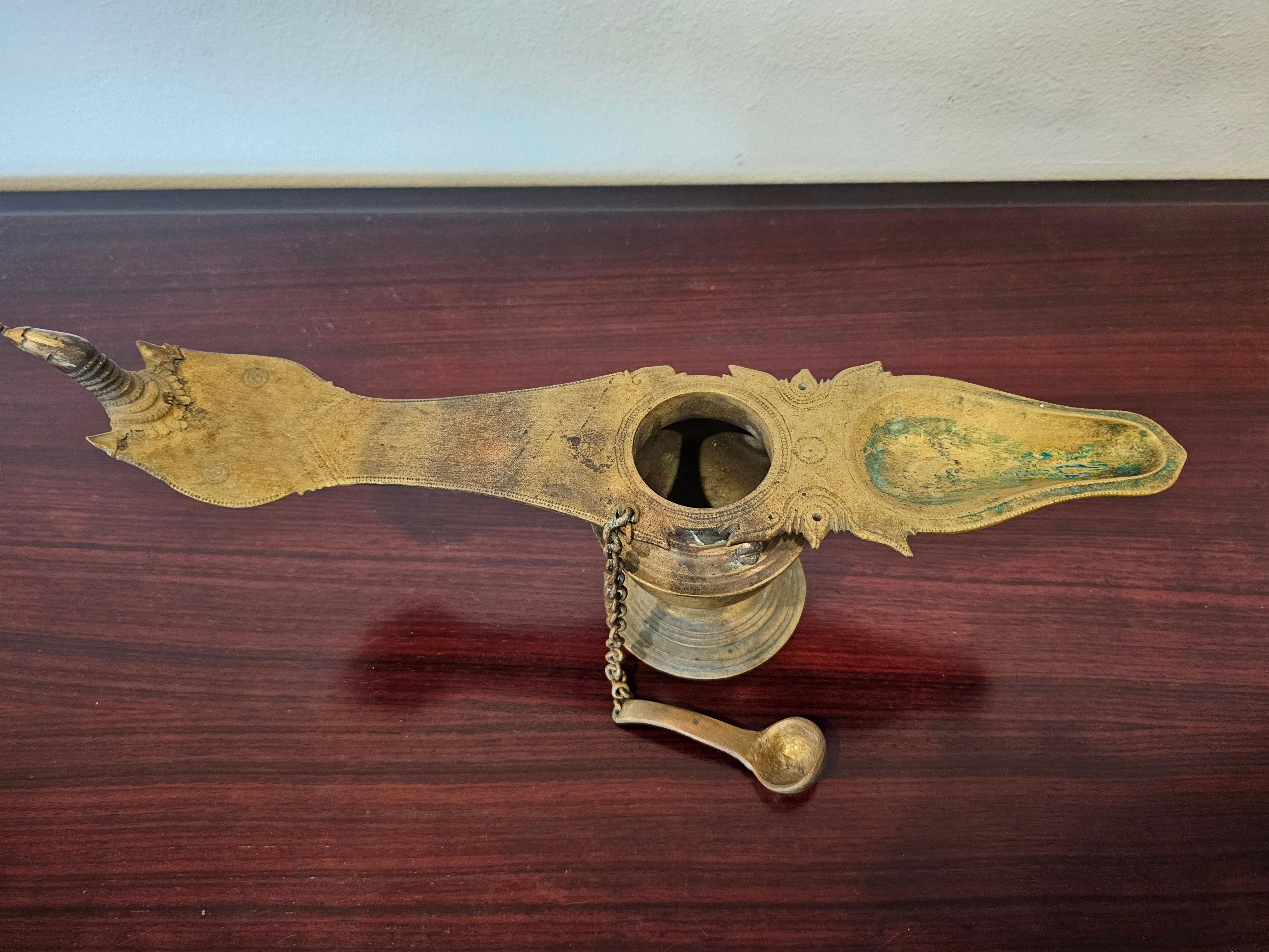 Add authentic antique character and charm, sophisticated cultural interest, elegant warmth and rich historical depth with this graceful South Indian patinated cast brass ritual oil lamp. 

This unique religious object, known as  Changalvetta, was