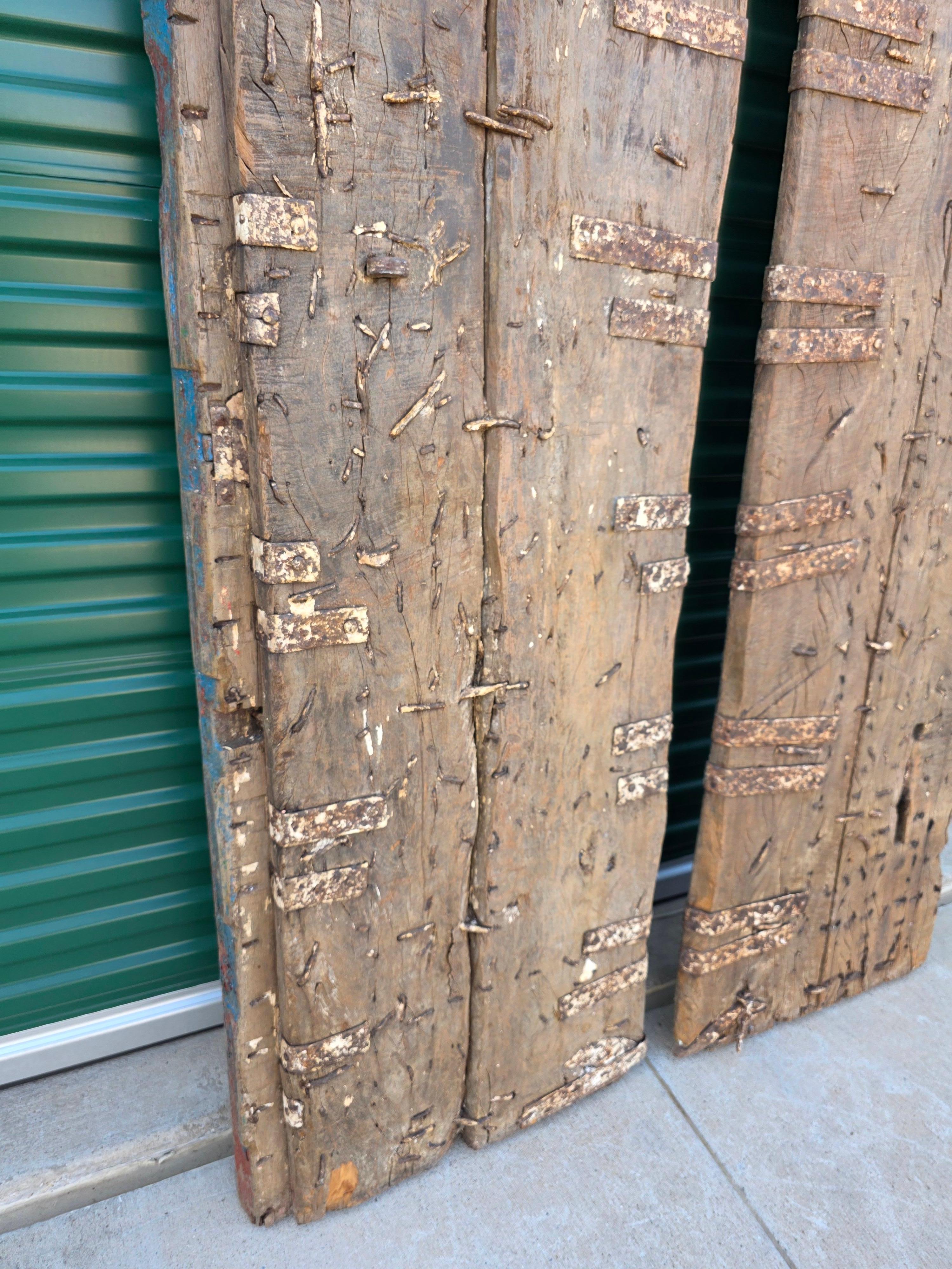 Paire de portes anciennes en bois de teck peintes sur métal, récupération architecturale d'un temple indien en vente 11
