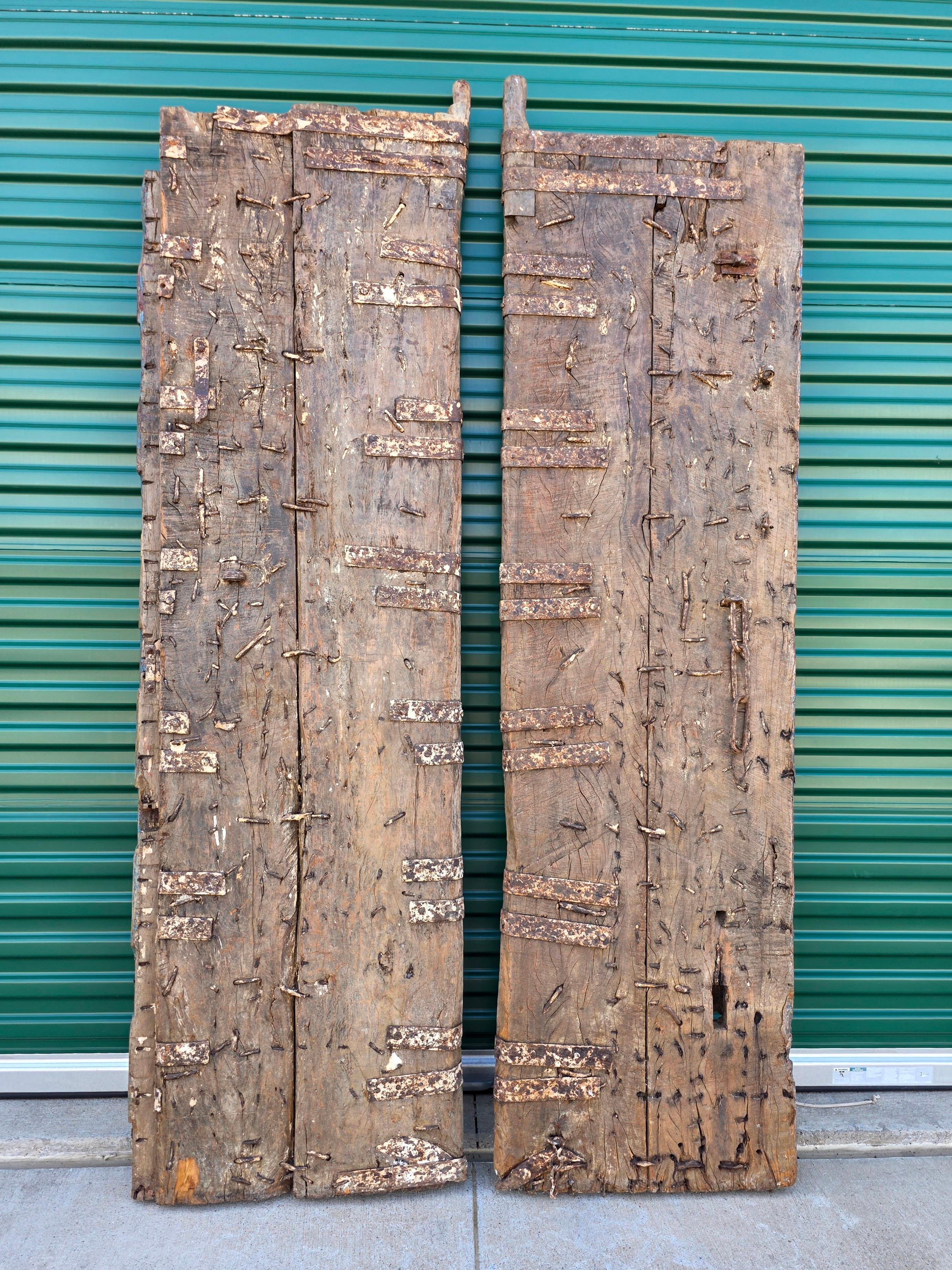 Sculpté à la main Paire de portes anciennes en bois de teck peintes sur métal, récupération architecturale d'un temple indien en vente