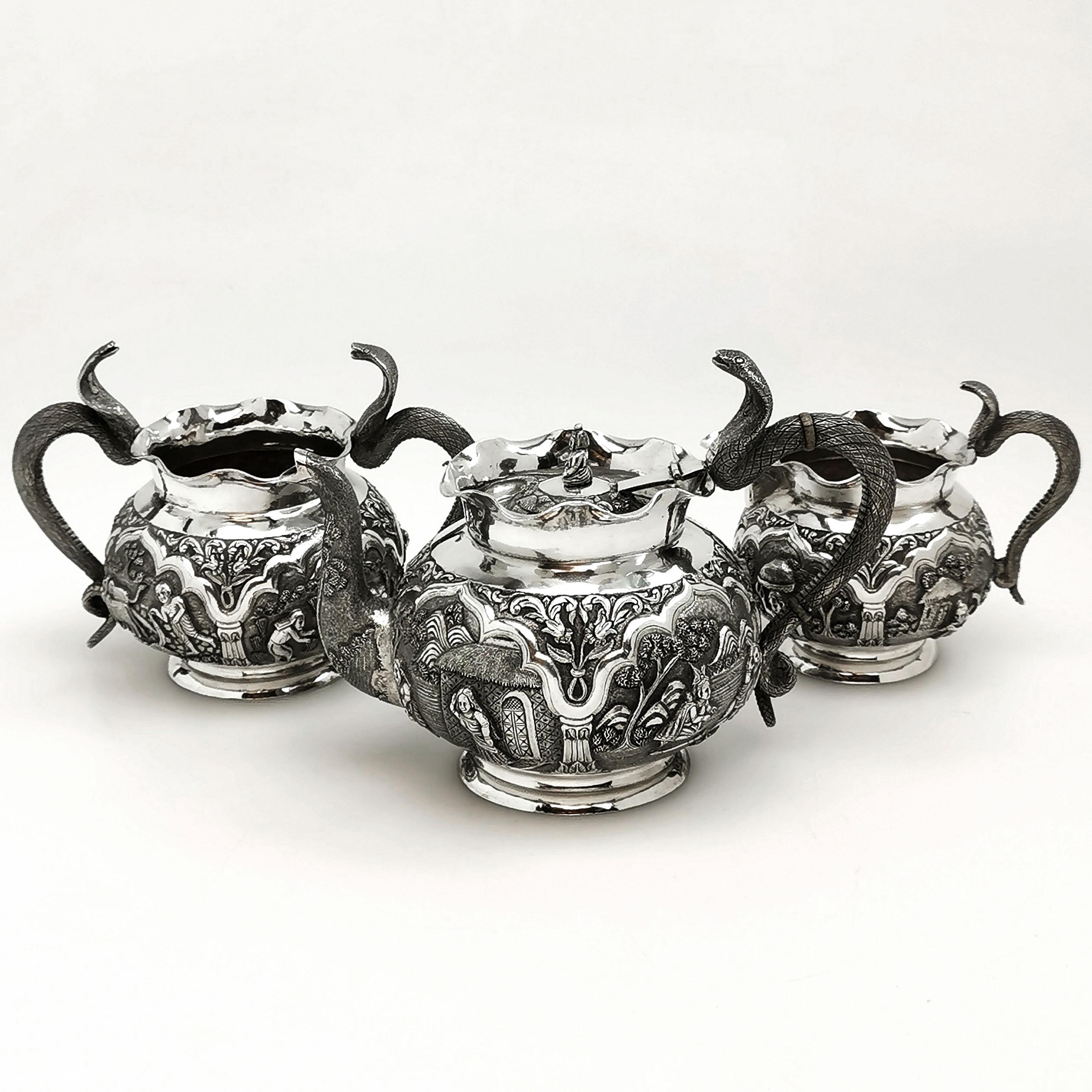 A magnificent antique Indian solid silver three-piece Tea Set comprising of a Teapot, a Milk / Cream Jug and a Sugar Bowl. Each piece features a gorgeous, detailed chased engraving around the body, and each has impressive Cobra Snake shaped handles.