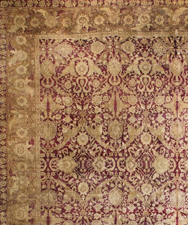 One of a pair of magnificent antique Agra rugs. The main field in the deep famous Agra reds filled with intricate floral designs in shades of golds to create a true sense of luxury. The main border in light shades continues the floral design and