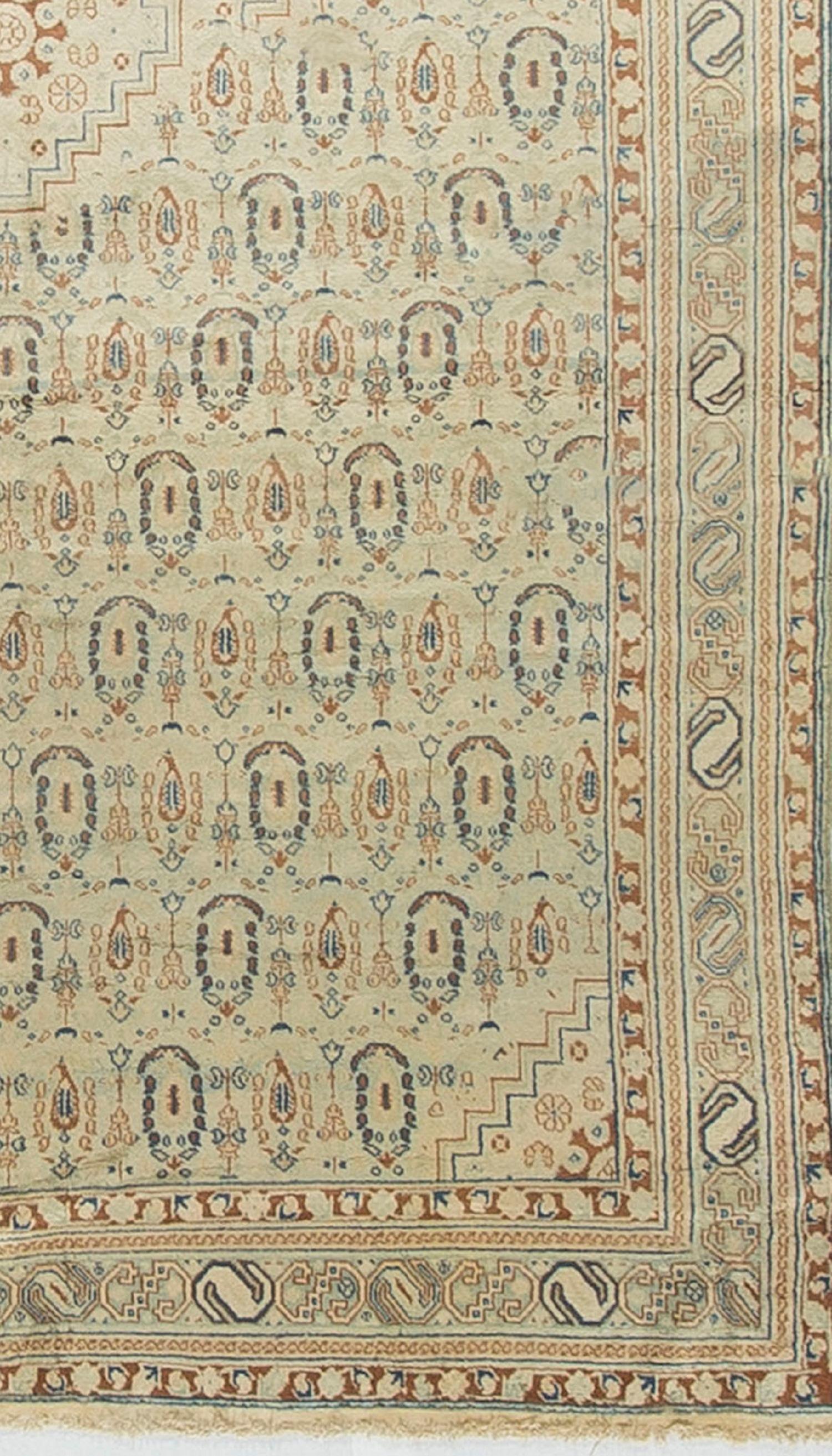 Indian Agra Rug Carpet Circa 1900. An antique handwoven Agra carpet, circa 1900. The main field filled with botheh's surrounding a central spinning wheel design. The lightness of the rug makes it able to work in all styles of design from classic