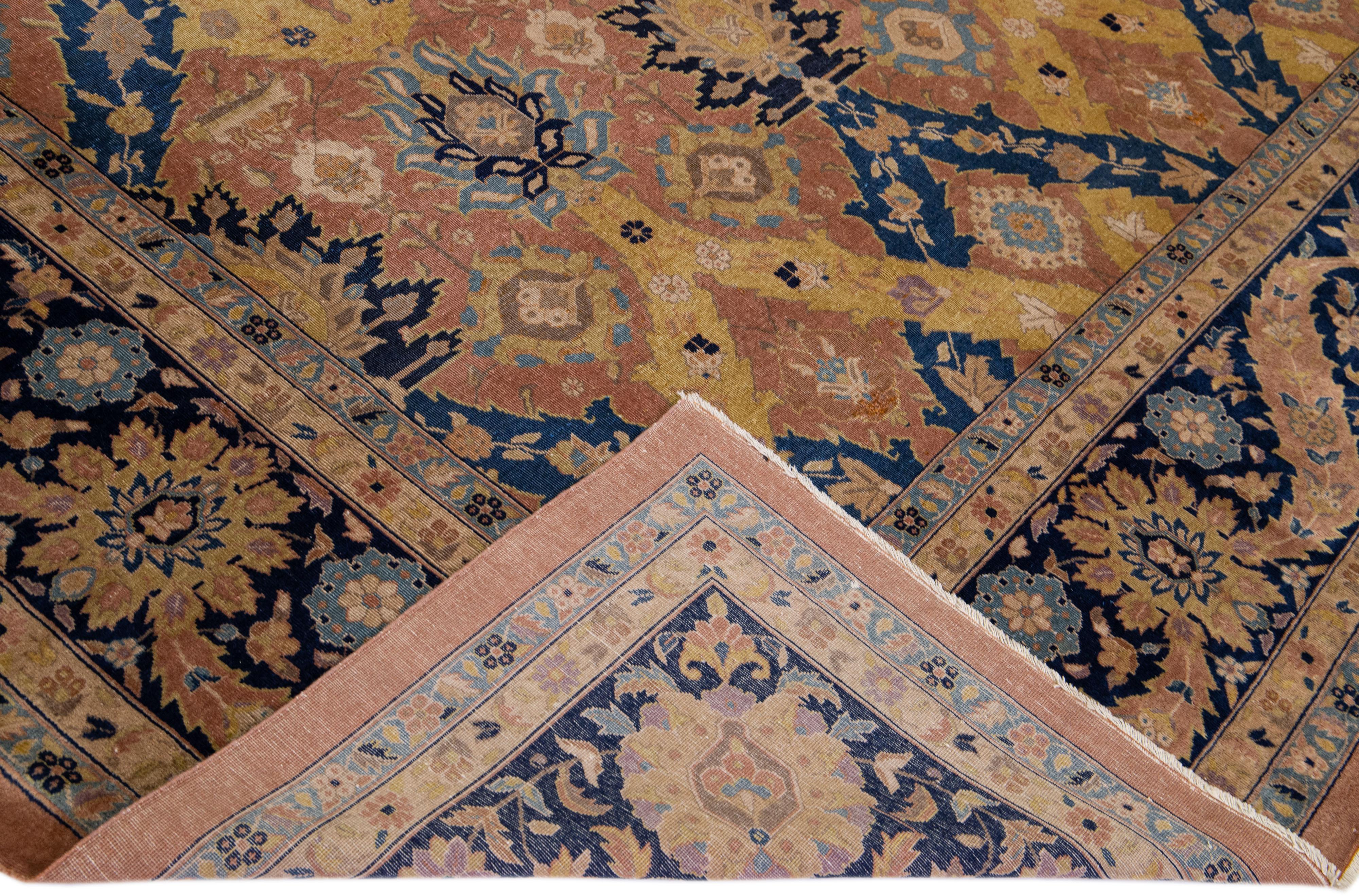 Magnifique tapis antique Agra en laine nouée à la main avec un champ de pêche. Ce tapis indien présente des accents multicolores dans un magnifique motif floral géométrique.

Ce tapis mesure : 11'5