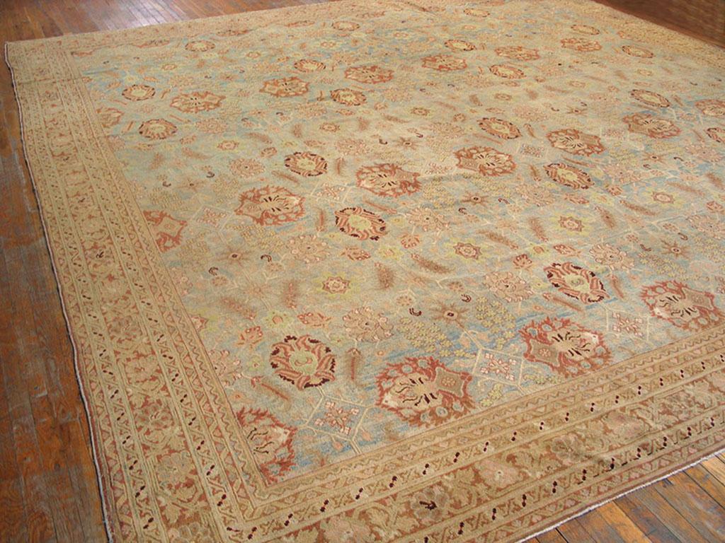 The light blue field shows a repeating pattern of rust-accented palmette quatrefoils, supported by lesser rosettes and serrated ‘fish’ leaves. The field abrashes to a sky blue near one end. Narrow rust main border with simple profile palmettes on a