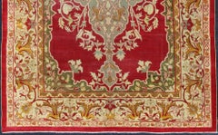 Indischer antiker Agra-Teppich mit Medaillon in der Mitte in Grün, Rot und Gold