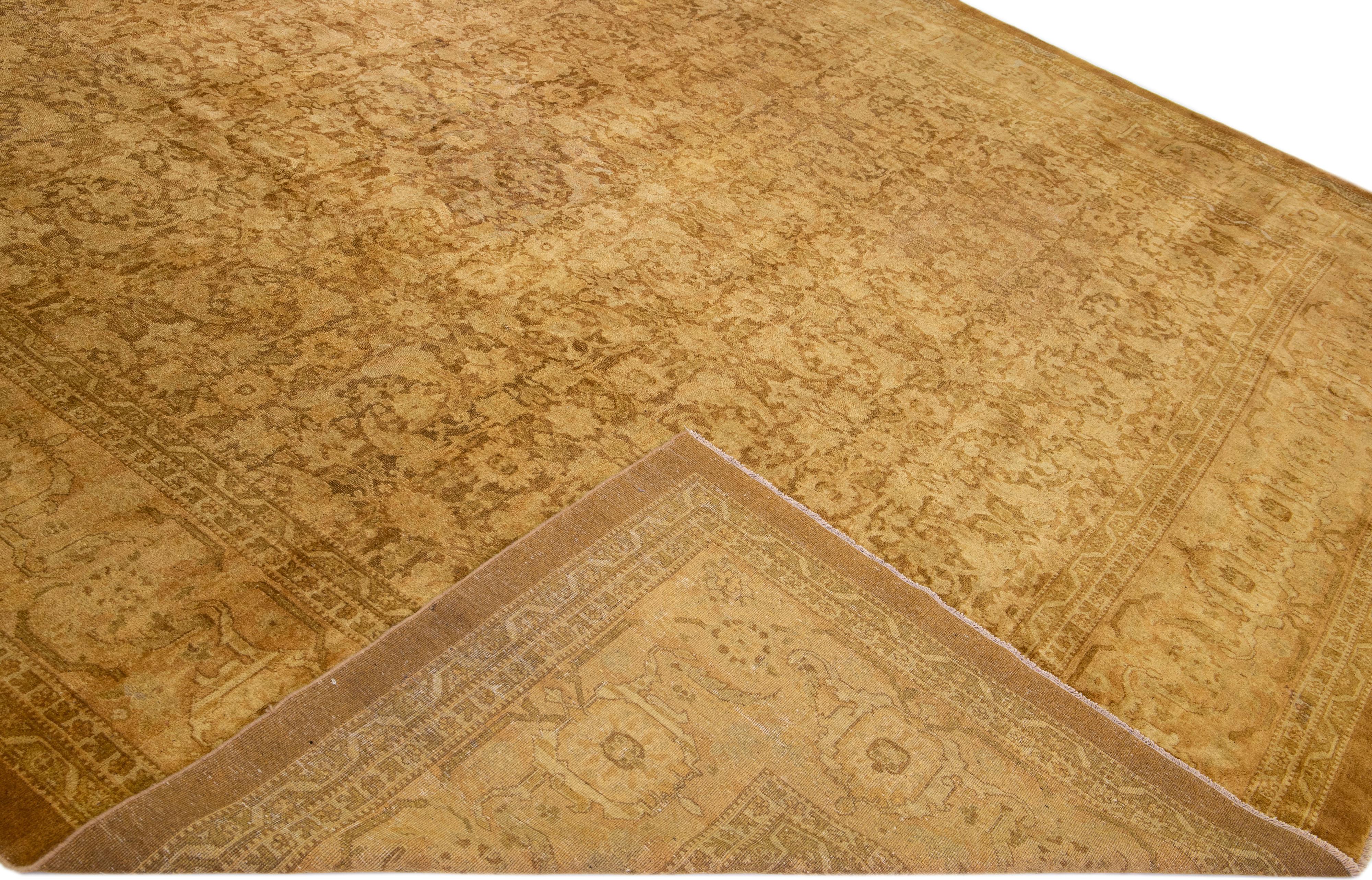 Beautiful antique Agra hand-knotted wool rug with a tan field. This Indian rug has brown accents in a gorgeous all-over floral pattern design.

This rug measures: 13' x 16'9''.