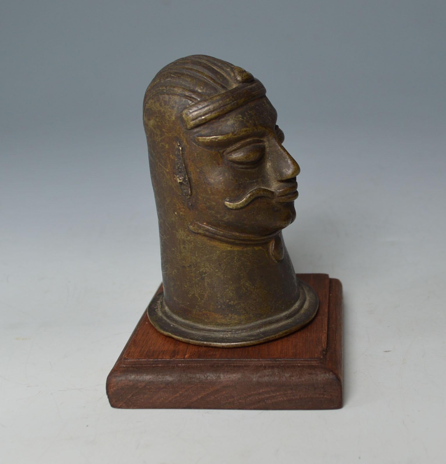 A fine antique Indian bronze alloy   head from a Shiva lingam.

The bronze alloy head in the image of Shiva with a long mustache 

Used to cover the Shiva lingam stone in Hindu temples. 

Measures: Height 11 cm. 4 1/2 inches

Condition: Good old
