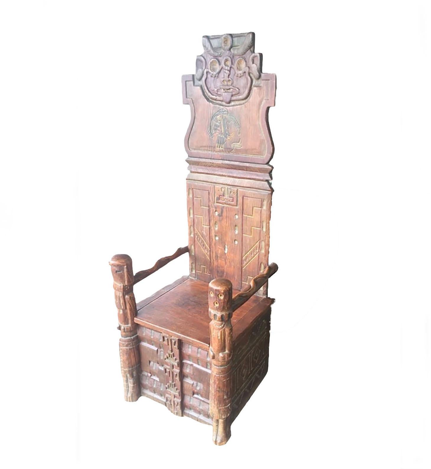 Très rare chaise indienne avec des visages sculptés dans le style de la côte nord-ouest. Serpents en bois sculptés sur les bras et visages Kachina sur les montants. Le siège se soulève pour être rangé. Américain, vers 1900 à 1910.