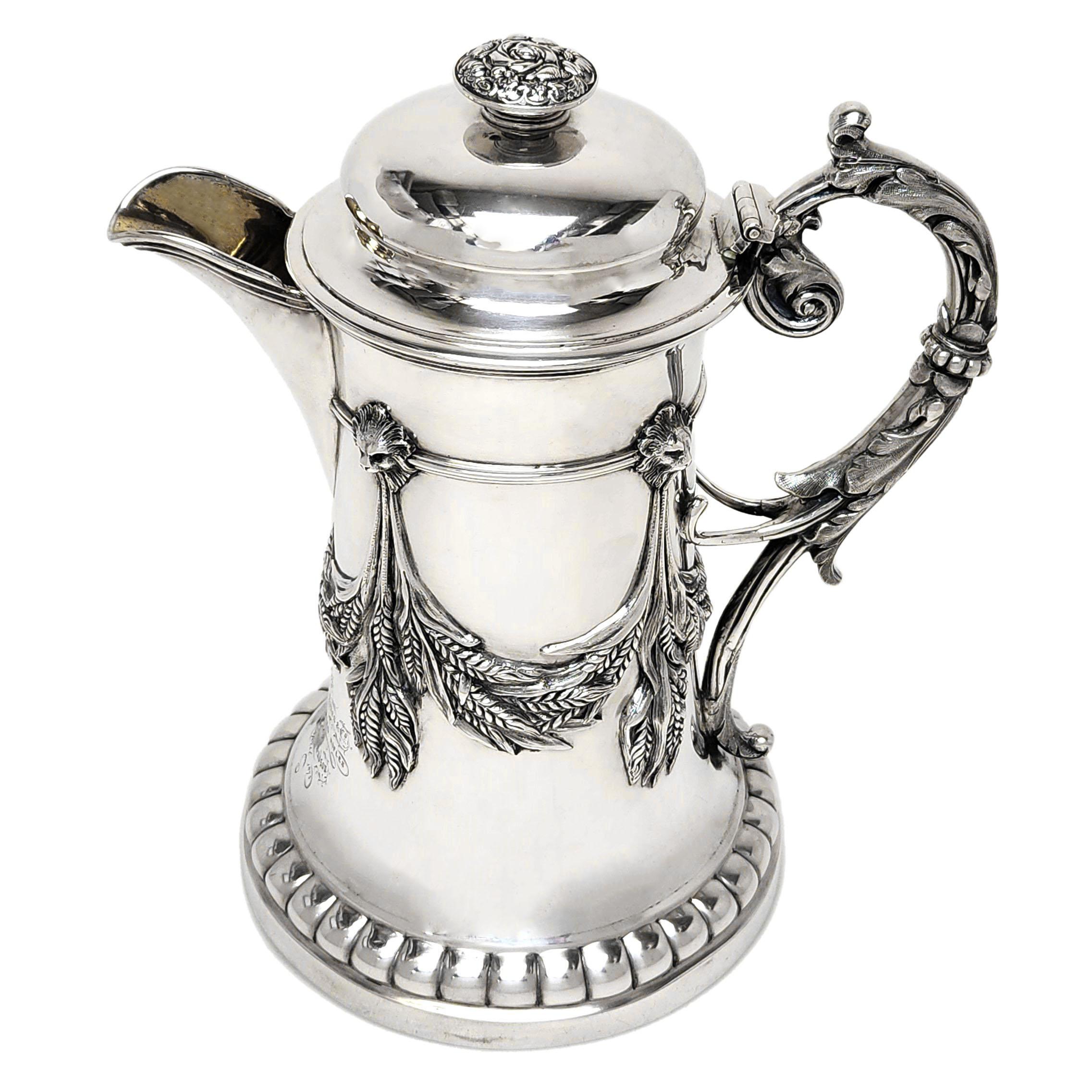 A magnificent Antique 19th Century Indian Silver Jug. This Jug has a tapered cylindrical form embellished with a cast applied band of lion heads holding impressive swags of wheat or barley which decorate the body of the jug. The Jug has an