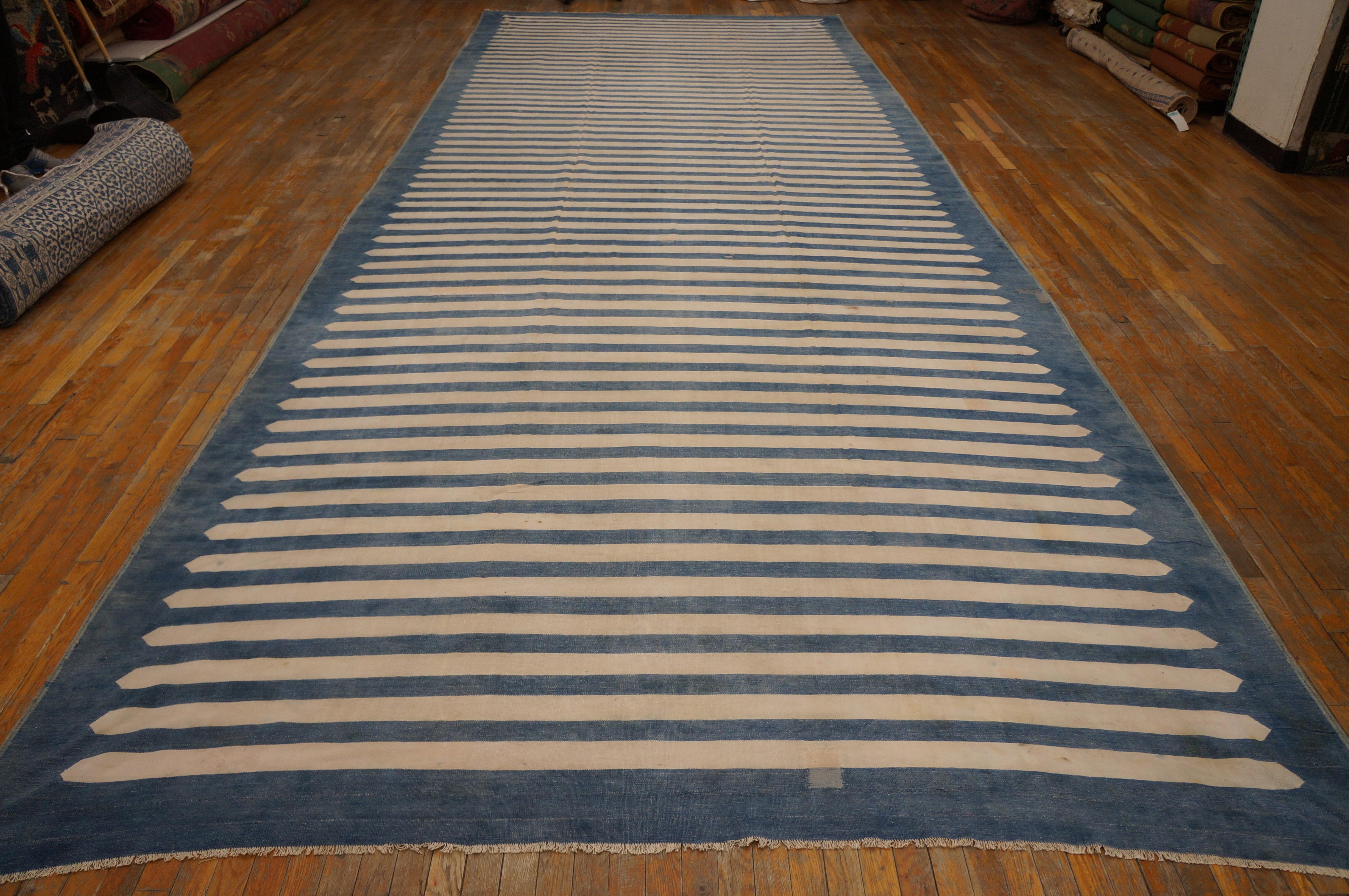 The bitonal horizontal stripe pattern, especially in ecru and light blue is a Dhurrie mainstay, and here the ecru stripes are pointed to neatly fit on the light washed denim blue ground. This vintage all-cotton pileless carpet is in good condition