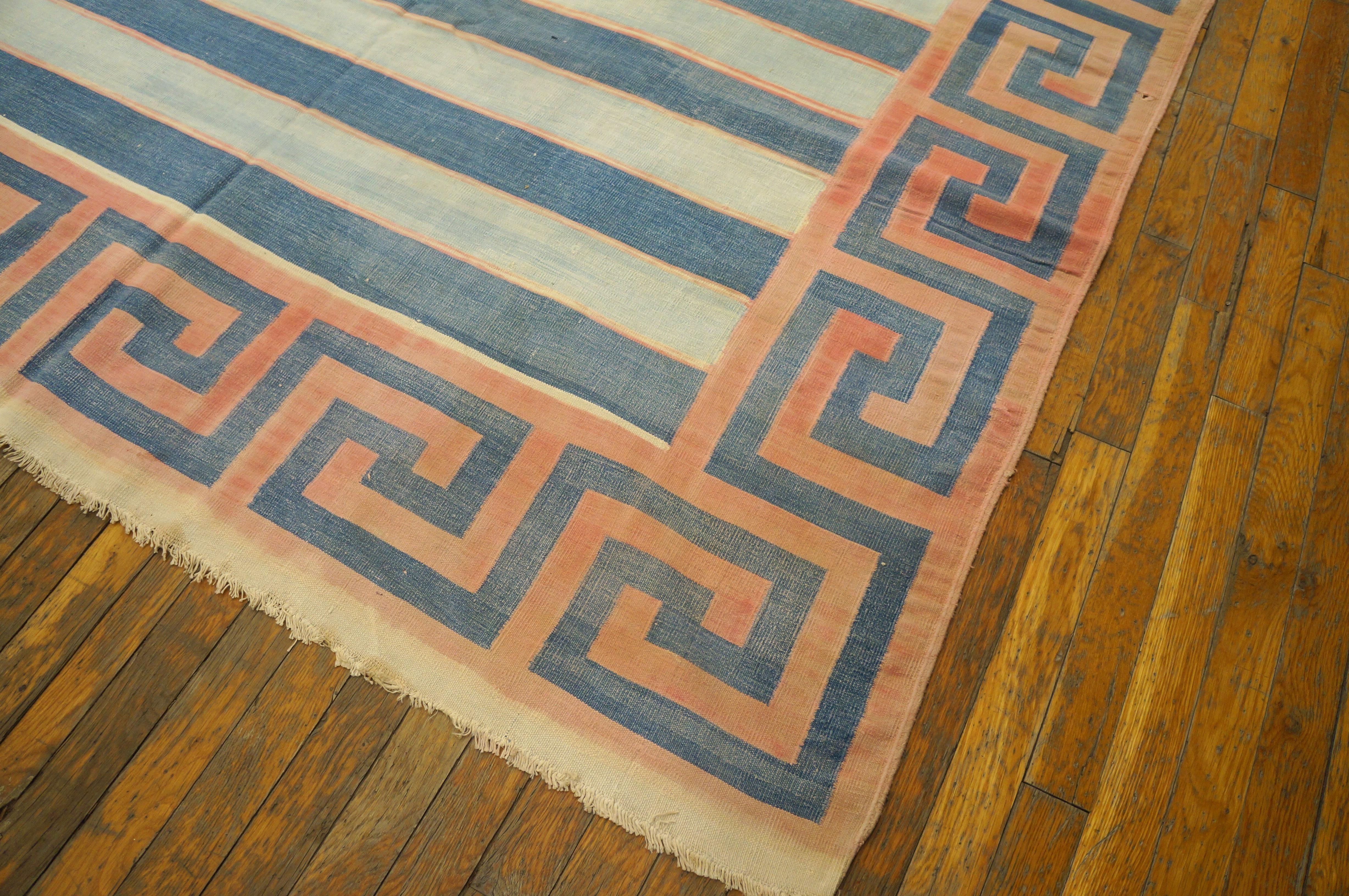 A bold pink and blue squared wave border neatly frames the blue and ecru striped field with the narrowest of hairlines edging the stripes. Antique in good condition. Measures: 9'0