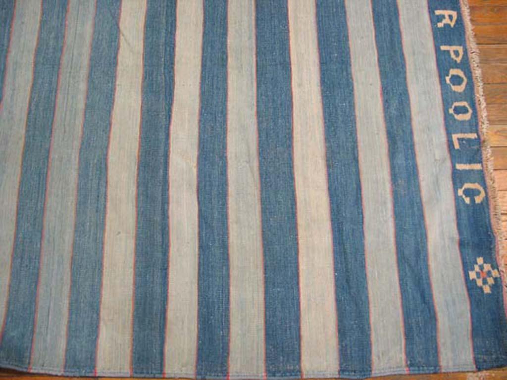 Dhurries are very rarely signed or marked by the weavers (s) or originating firm, but here a large gallery-carpet format all cotton bitonal blue-and-white striped piece is signed “M. Ahmad Hasan Thanadarpoo LIC. Make this read how you want. Ahmad