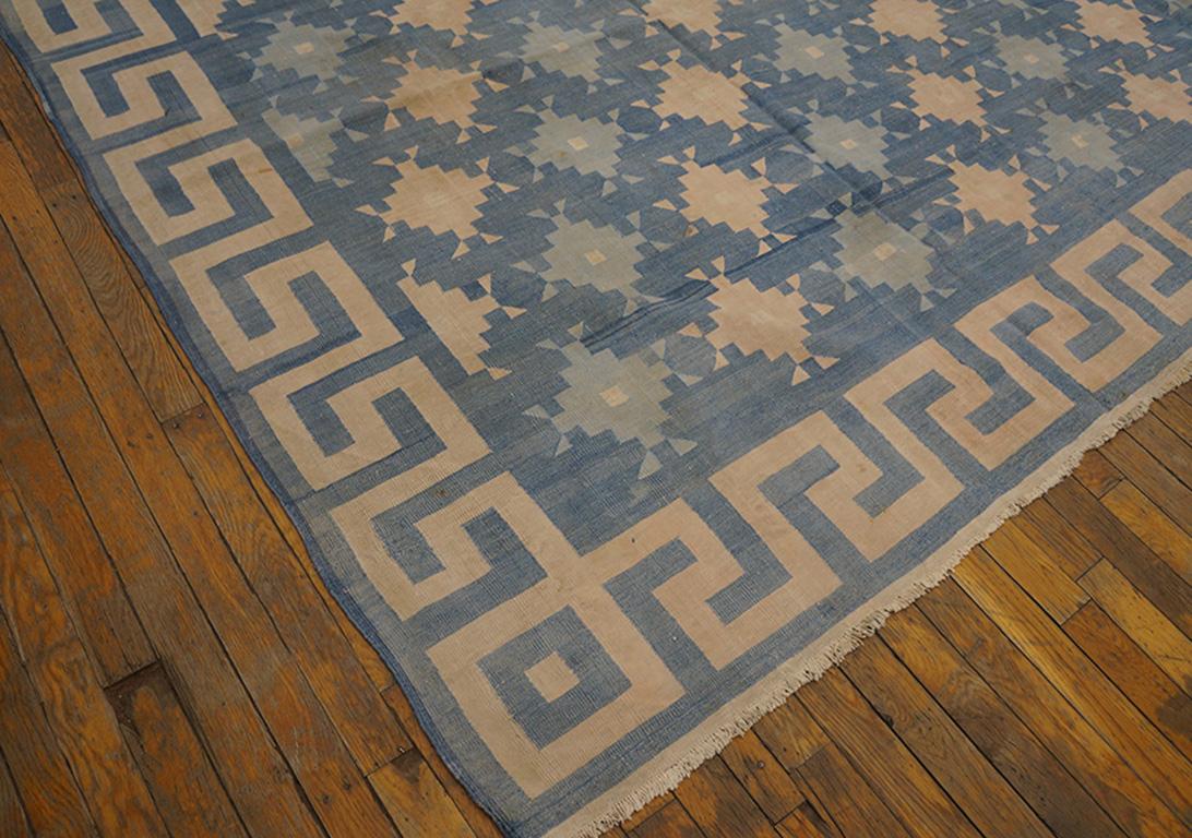 Denim blue looks good on the abrashed field with its offset half-drop rows of stepped diamonds in buff or pale teal or ecru. Bold squared wave border. Antique flat-woven all-cotton Indian piece with a seaside palette and in good condition.