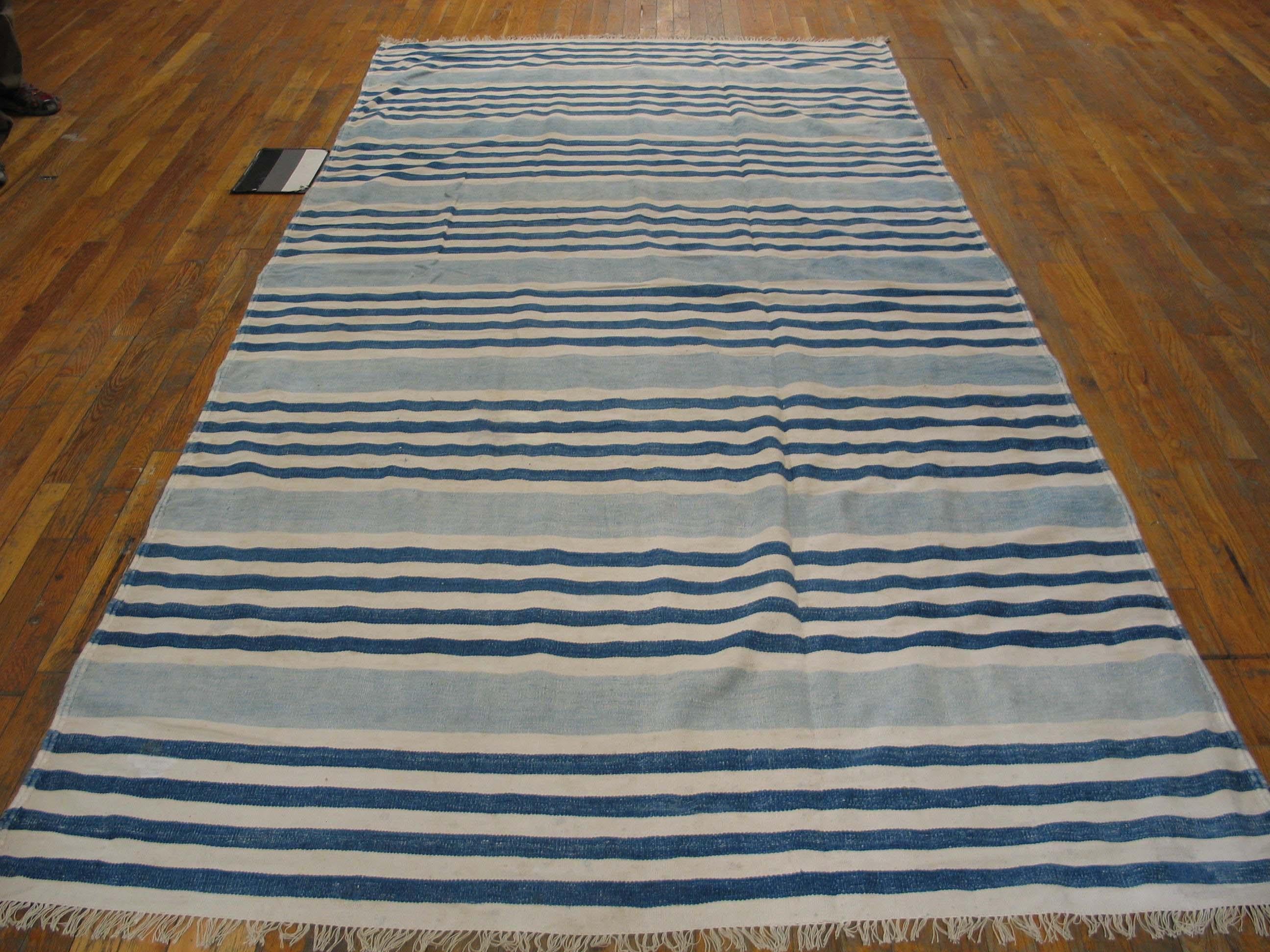 Nine bunches of ecru and denim blue lines, all running borderless along the sides, are divided by wide powder blue stripes on this long-rug (kellegi) format all-cotton Indian antique to vintage flat-weave in good condition. Versatile size,