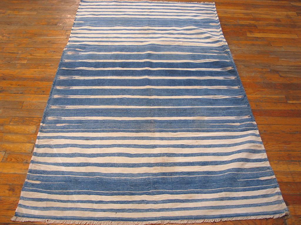 A basically blue and white borderless stripe design features numerous small, but effective details including slender spearheads, feathered arrows and small pointed projections. This is a large Dhurrie shrunk down to scatter size and has lost nothing