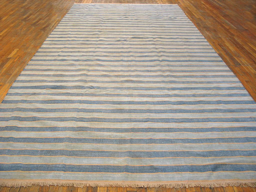 A virtually infinitely size adjustable gallery carpet format Indian bitonal flat-weave with full width stripes in ecru and cleverly abrashing medium blue. With all cotton construction and good condition. Narrowest pale yellow lines add a subtle