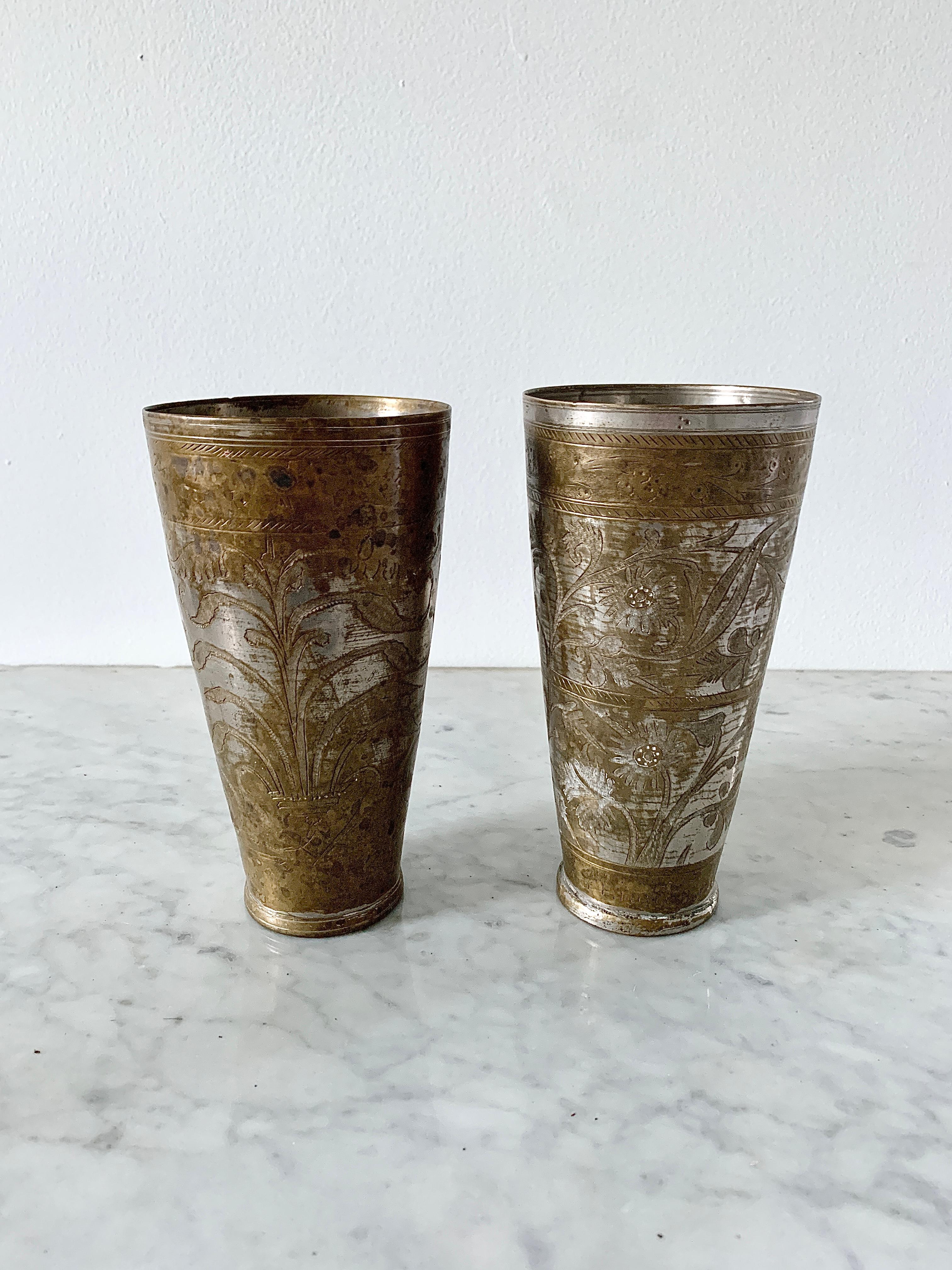 A pair of antique etched brass metal lassi cups that would make beautiful vases. Lassi is a blend of yogurt, water, spices, and sometimes fruit. For generations, lassis were served in patinated metal and brass cups in India. Hand-engraved in the