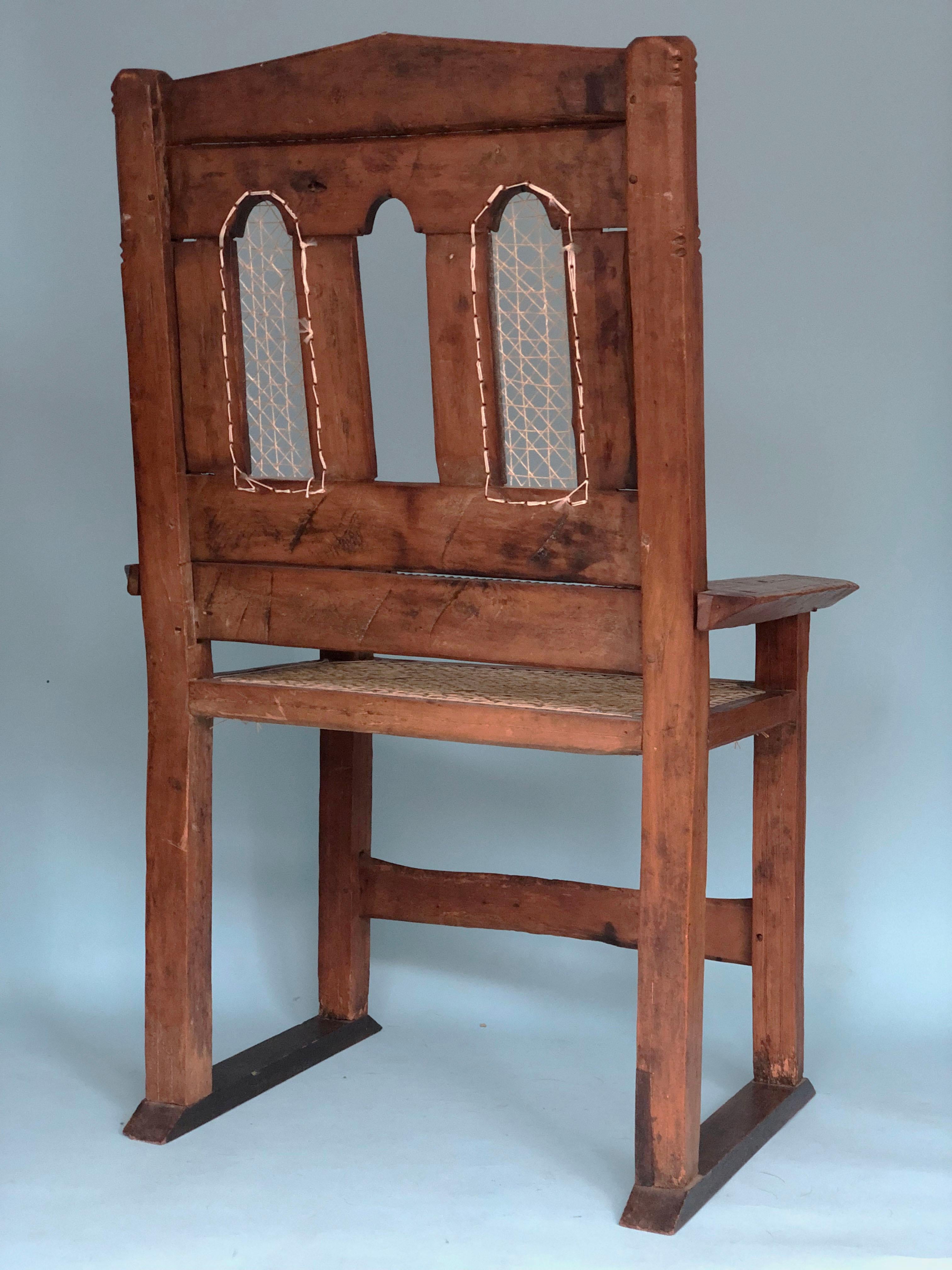 Ein schöner handgeschnitzter indischer Stuhl aus Teakholz. Das reiche Aussehen des Stuhls wurde mit einem neuen Seil für Sitz und Rückenlehne versehen, so wie es früher einmal war. In der Armlehne des verwitterten Stuhls ist ein Name