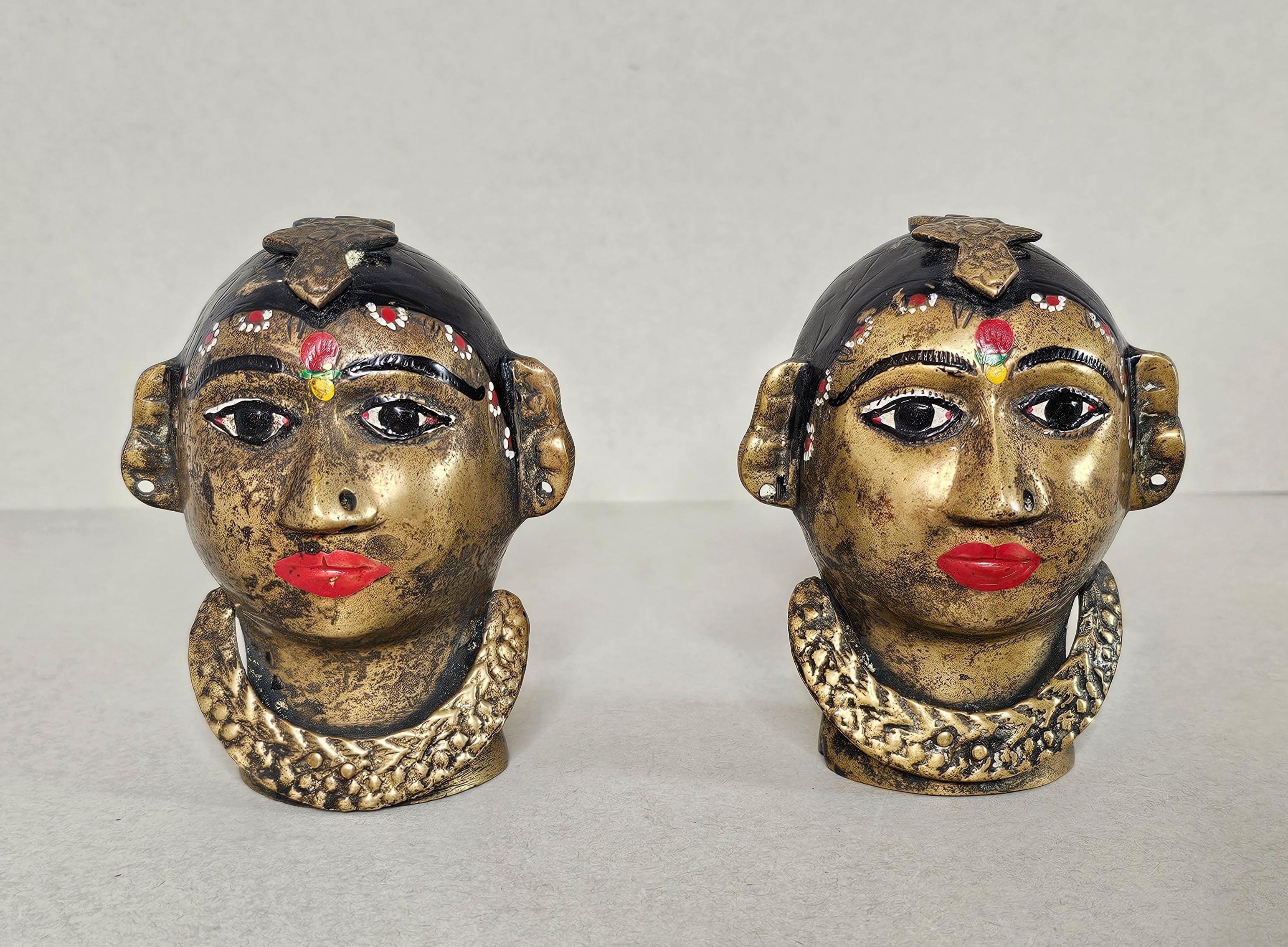 A pair of antique Indian hand-painted figural brass head religious sculptures. 

Hand-crafted in the Maharashtra or Karnataka region of India in the late 19th / early 20th century, depicting Gauri, exceptionally executed in brass with polychrome