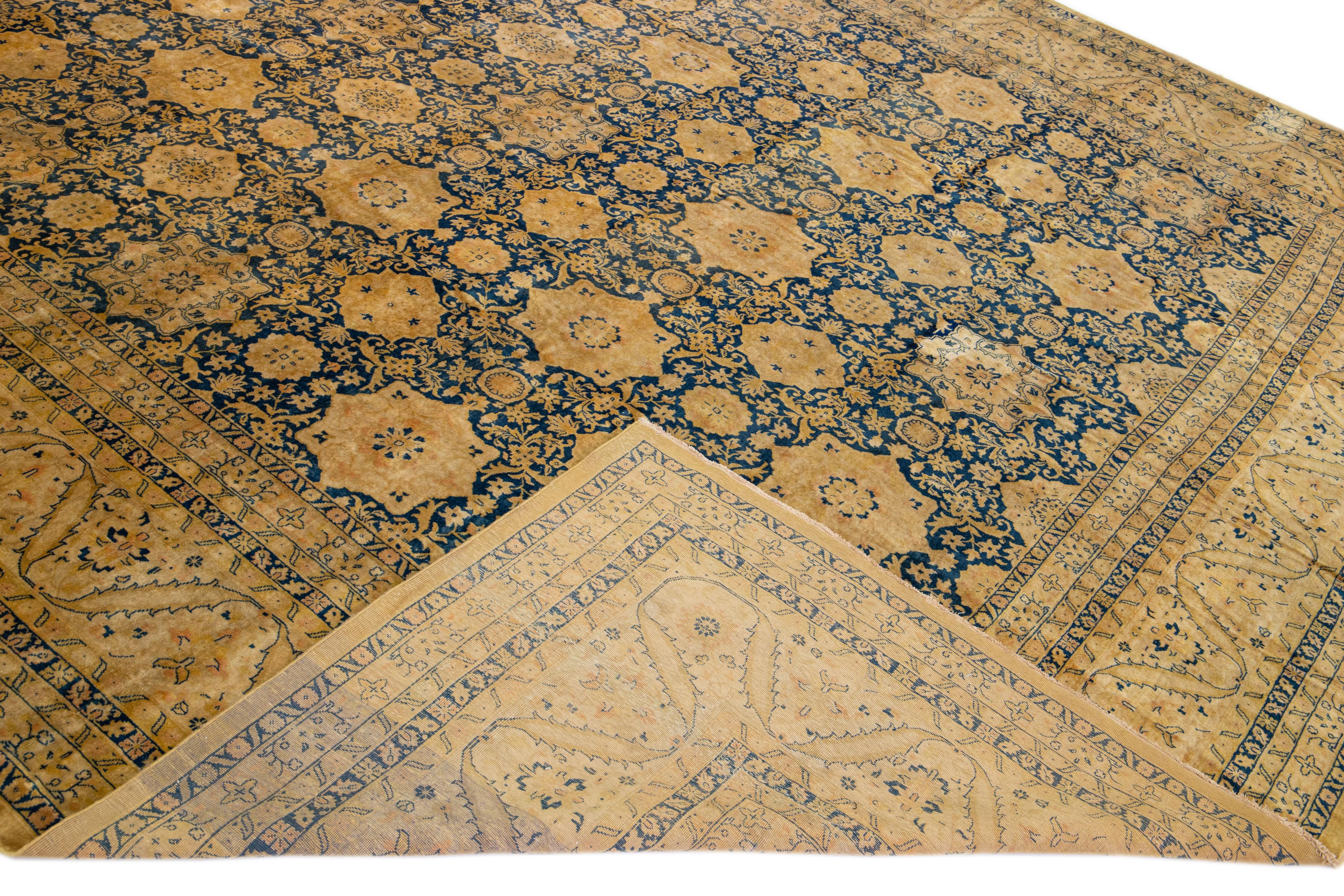 Schöner antiker handgeknüpfter Wollteppich mit blauem Feld. Dieser indische Teppich hat hellbraune Akzente in einem prächtigen Allover-Rosettenmuster.

Dieser Teppich misst: 11'6