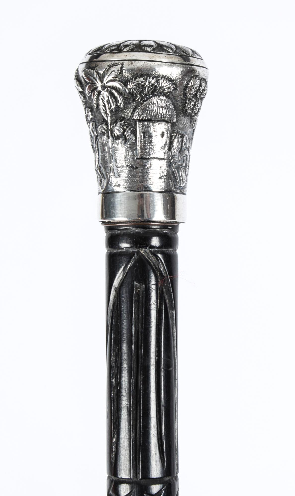 This is a beautiful antique Indian gentleman's silver pommel and hardwood walking stick, circa 1880 in date.
 
This decorative walking cane features an exquisite silver pommel decorated with exquisitely cast palm trees and a figure of farmer and