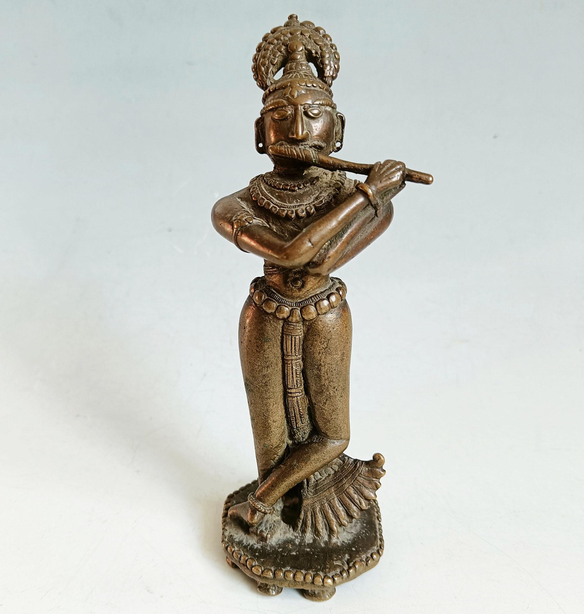 Antike indische Hindu-Bronzeskulptur - Krishna mit Flöte (18. Jahrhundert)

Eine fesselnde und fein gearbeitete antike Bronzefigur, die Lord Krishna in der charakteristischen Tribhanga-Haltung (dreifache Beugung) mit einem anmutig umgedrehten Fuß