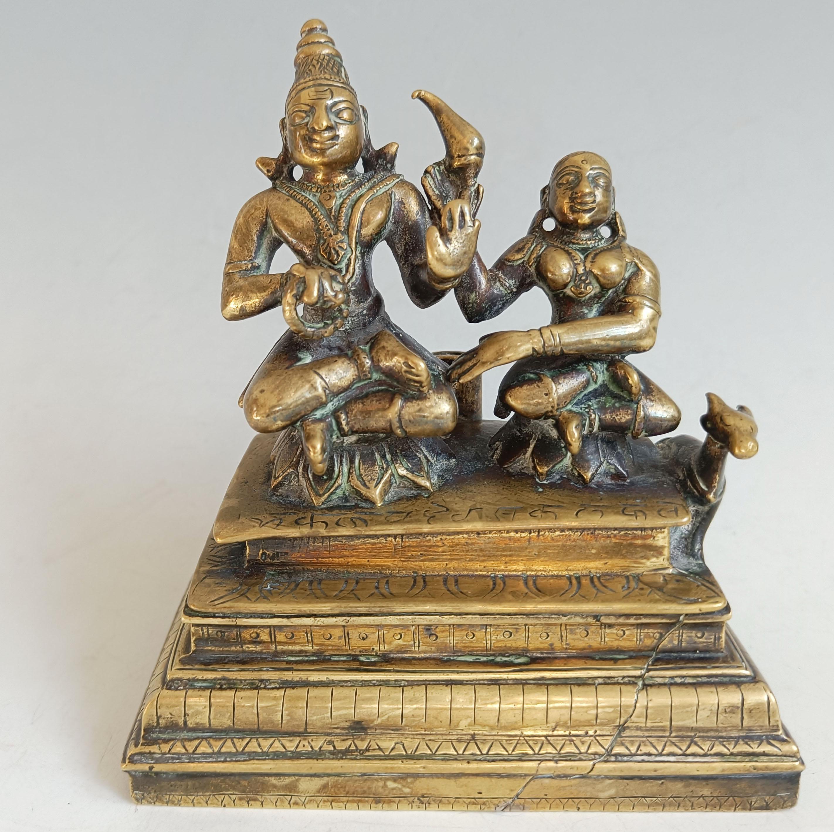 Antica figura indiana indù in bronzo - Shiva e Parvati
Un bronzo massiccio del XVIII secolo di squisita fattura che raffigura la coppia divina, Shiva e Parvati, seduti in posizione aggraziata su un basamento a gradini. Le figure sono ricche di