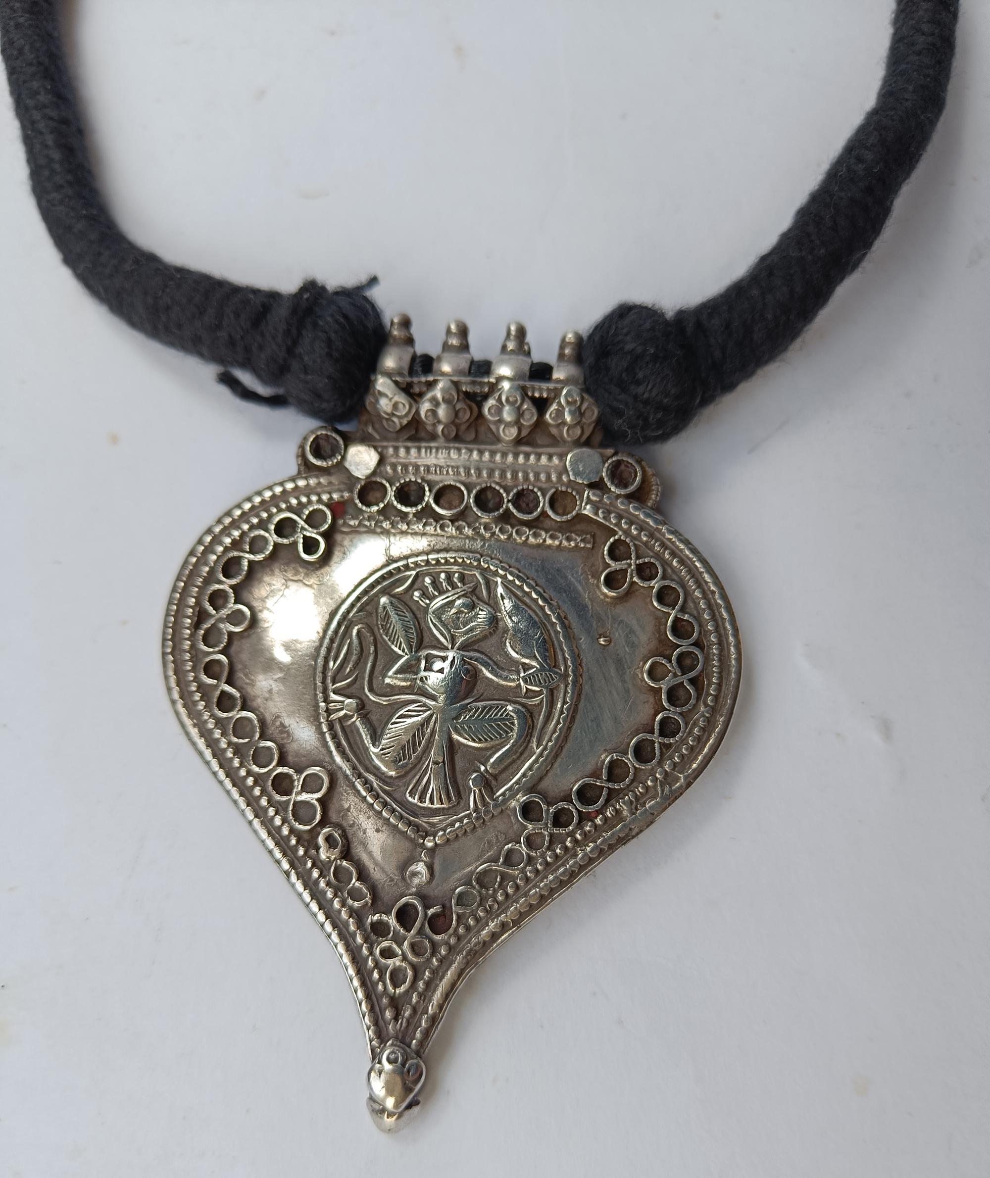 Antike indische Hindu Silber Amulett Halskette 
Zeitraum 19. Jahrhundert
Hochwertiges Silber  
Anhänger Länge 8 x 6   cm  Gewicht 60 Gramm
Zustand: Gut.
Restrung auf Baumwolle.
 
 
