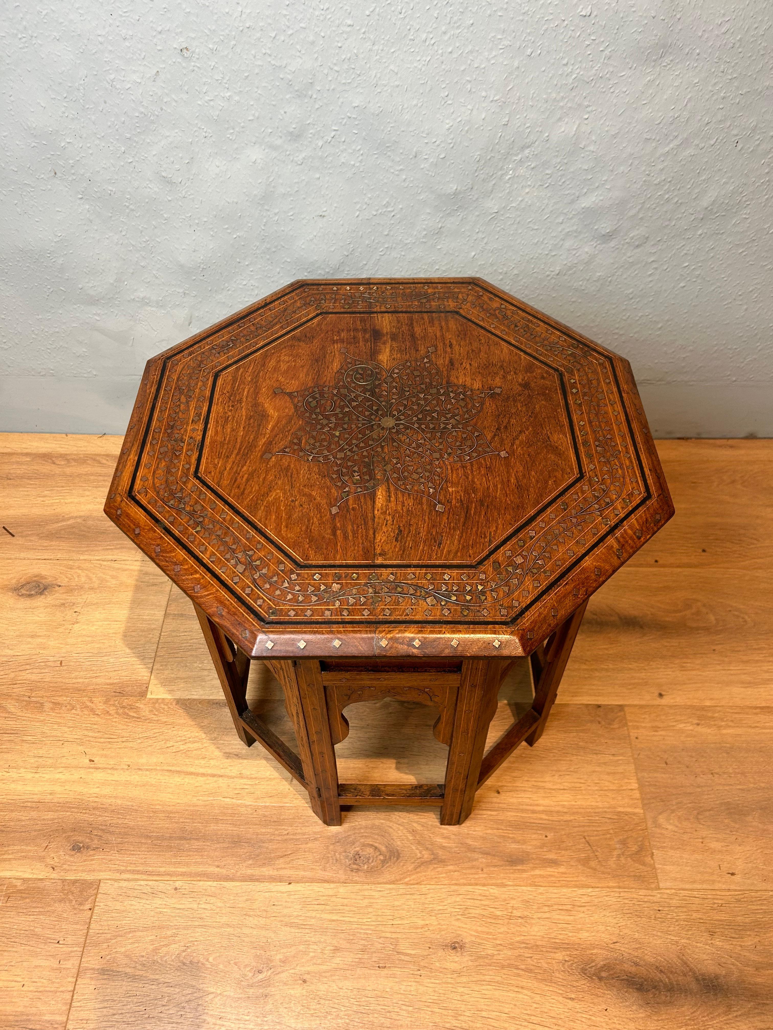 Indian hoshiarpur table circa 1880, profusely inlaid with brass and an ebony and box wood stringing line to the perimeter, the eight sided base each has an insert panel and below shaped myriads. The table is a pleasant light honey colour.