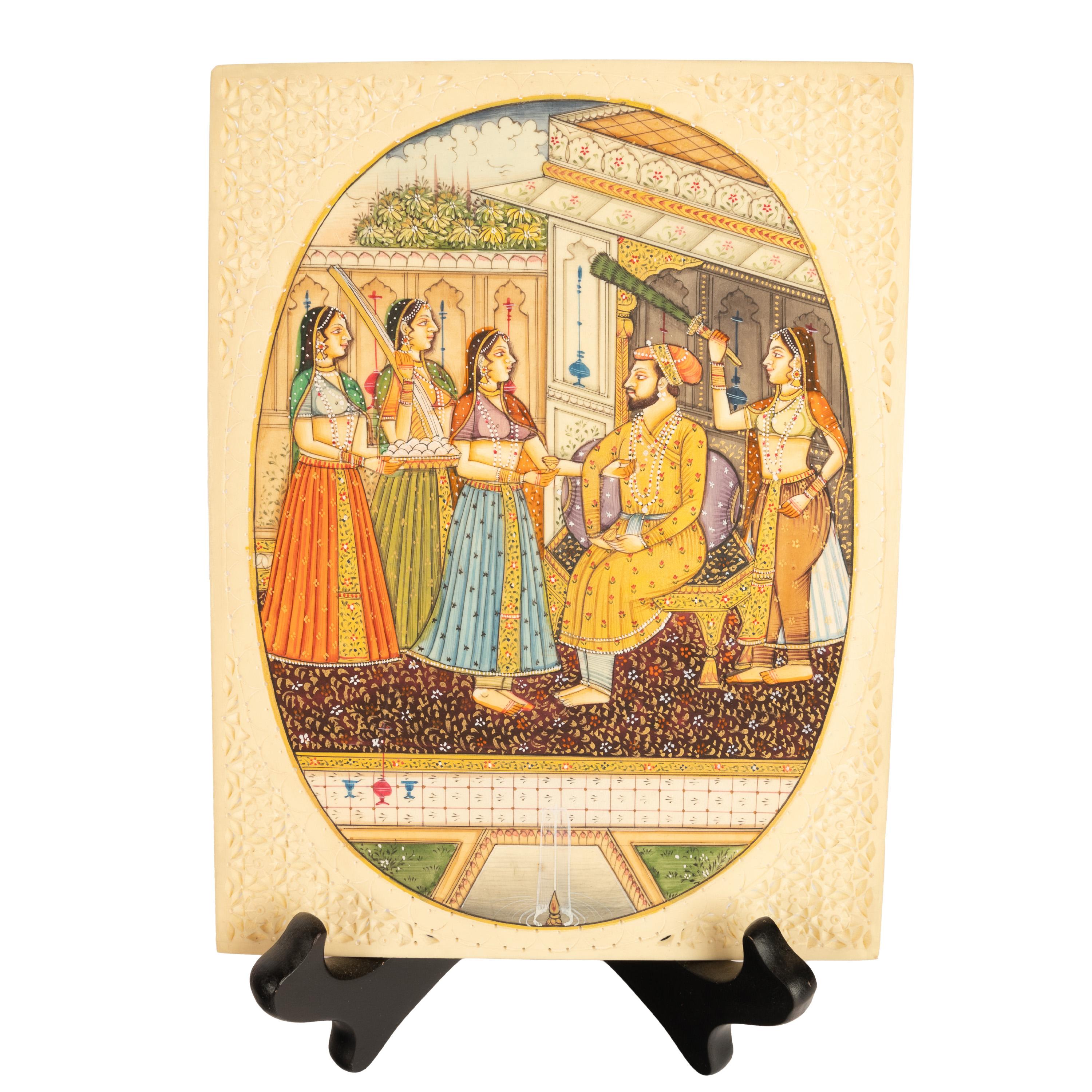 A fine antique Indian Mughal Miniature painting, in a carved camel bone frame. Circa 1900.
The painting of oval outline is very finely rendered and depicts the seated Shah in the grounds of a lavish palace, the Shah with three female attendees with